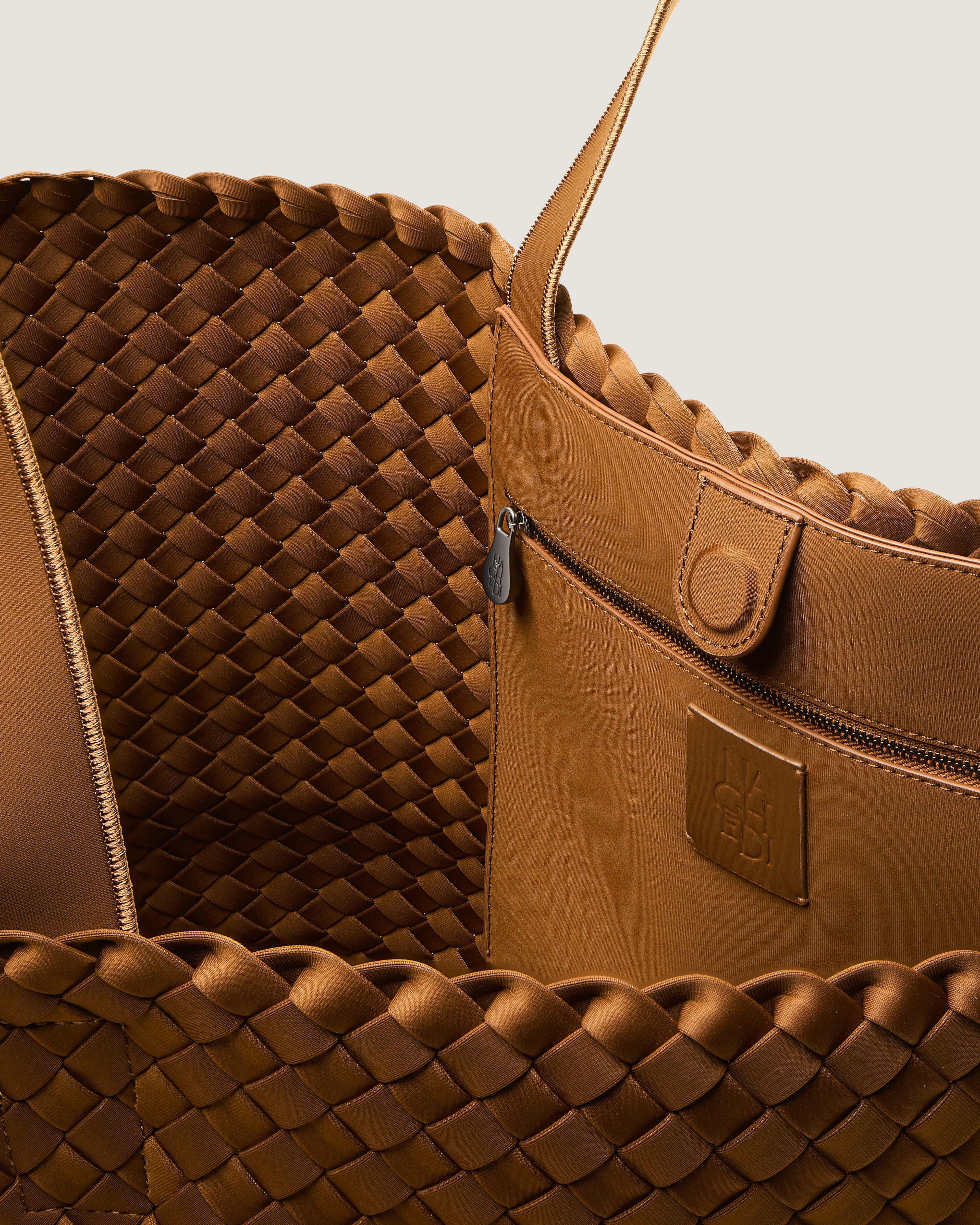 Interior close-up of Como Tote in Teak showing its open top with magnetic snap closure, interior zip pocket, and unlined interior.