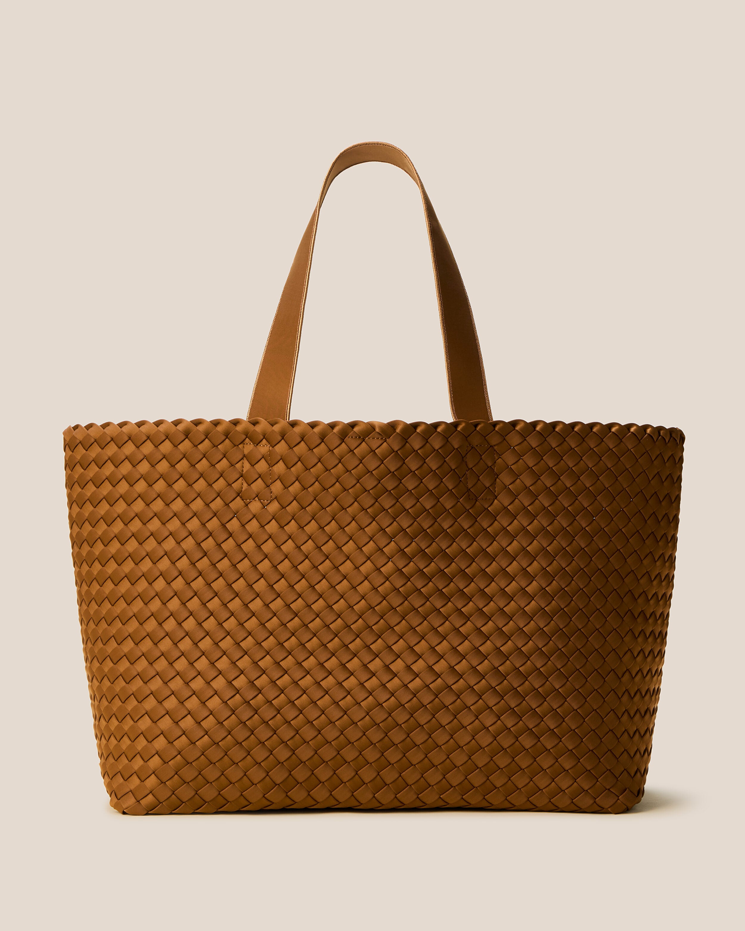 Como Tote in Teak, a saddle brown tone, in handwoven neoprene, featuring an open top with magnetic snap closure, and neoprene shoulder straps.