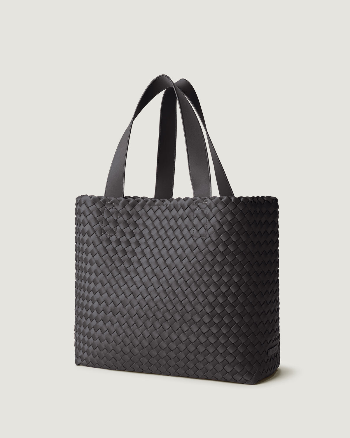 Como Tote in Ash shown from a side angle, highlighting its handwoven neoprene construction and open top with magnetic snap closure.