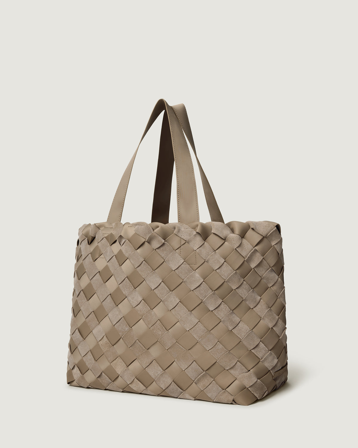 A large handwoven suede and neoprene tote bag in a taupe-beige color, featuring a structured basketweave pattern and two shoulder straps.