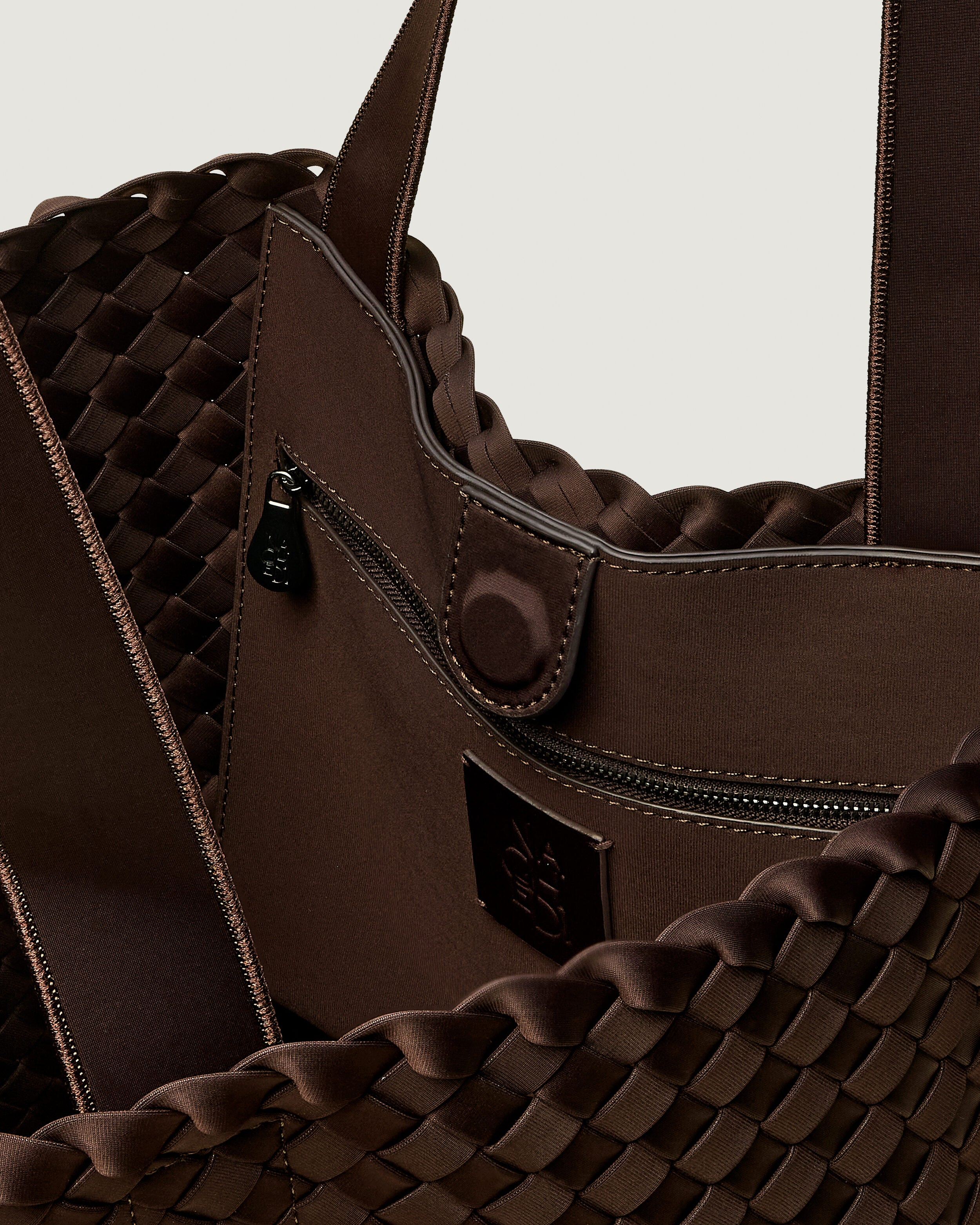 Interior close-up of Como Tote in Chocolate showing its open top with magnetic snap closure, interior zip pocket, and unlined interior.