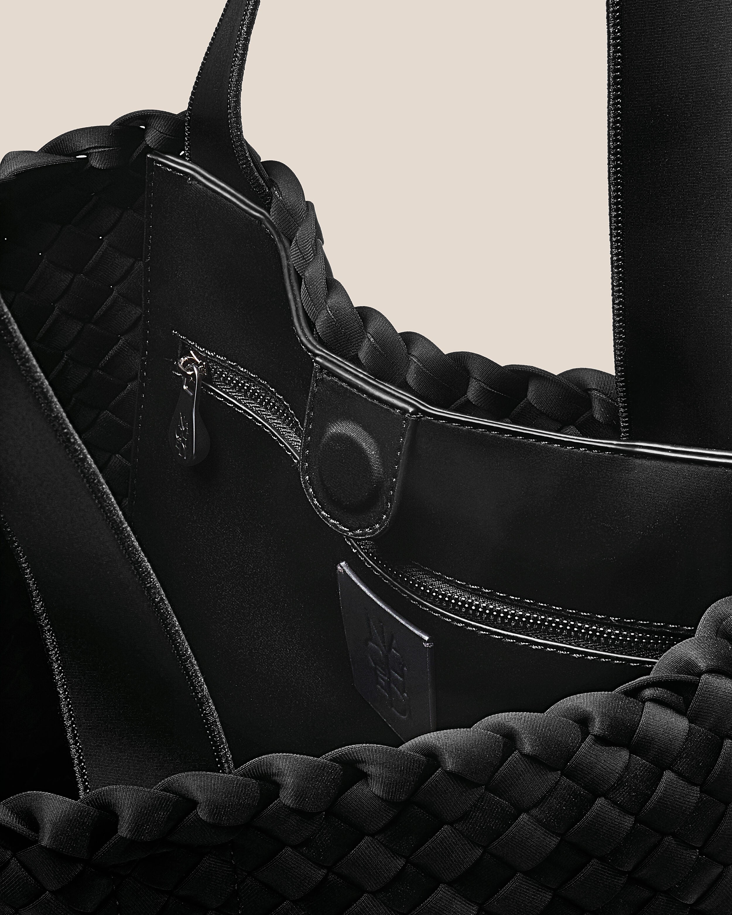 Interior close-up of Como Tote in Onyx showing its open top with magnetic snap closure, interior zip pocket, and unlined interior.