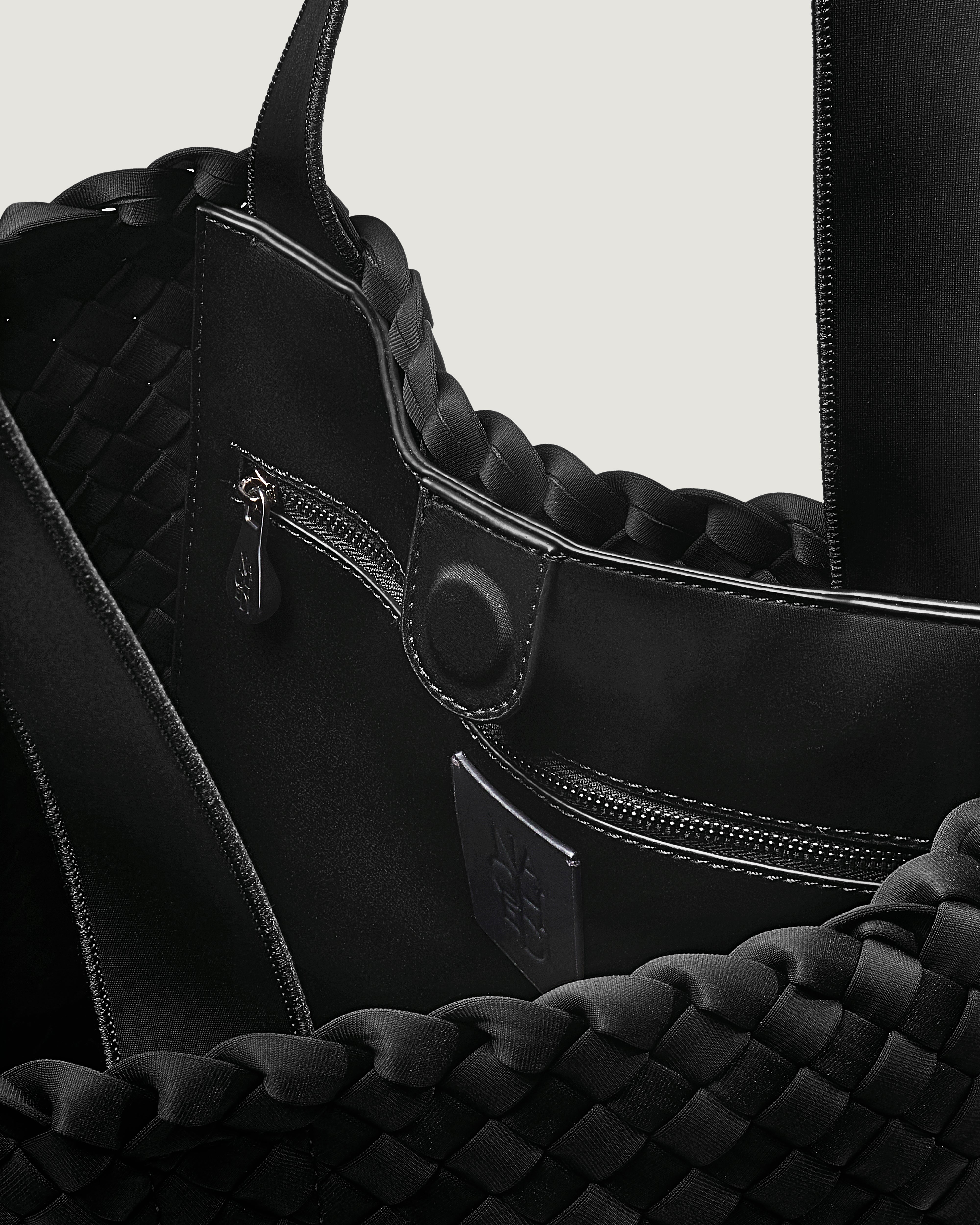 Interior close-up of Como Tote in Onyx showing its open top with magnetic snap closure, interior zip pocket, and unlined interior.