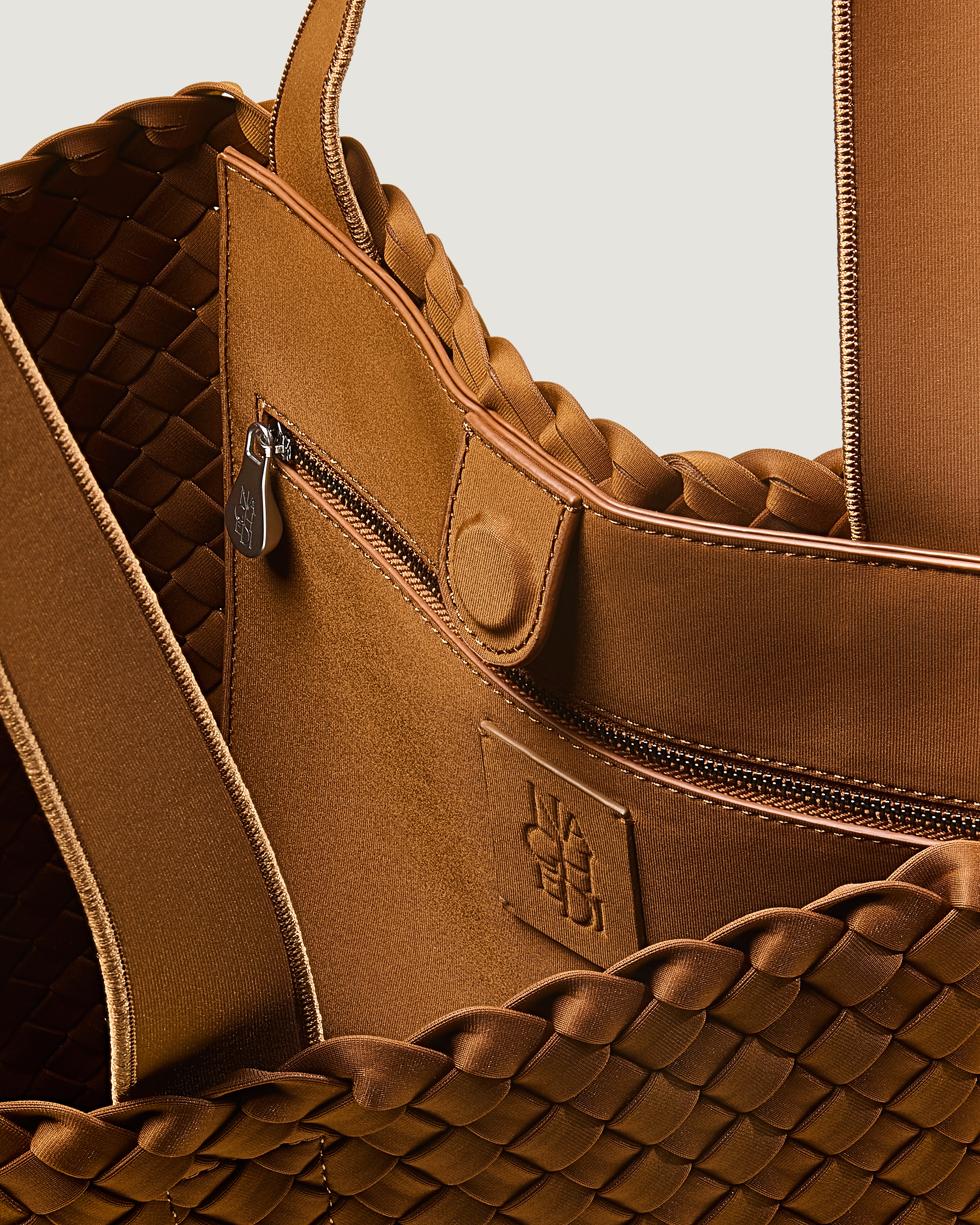 Interior close-up of Como Tote in Teak showing its open top with magnetic snap closure, interior zip pocket, and unlined interior.