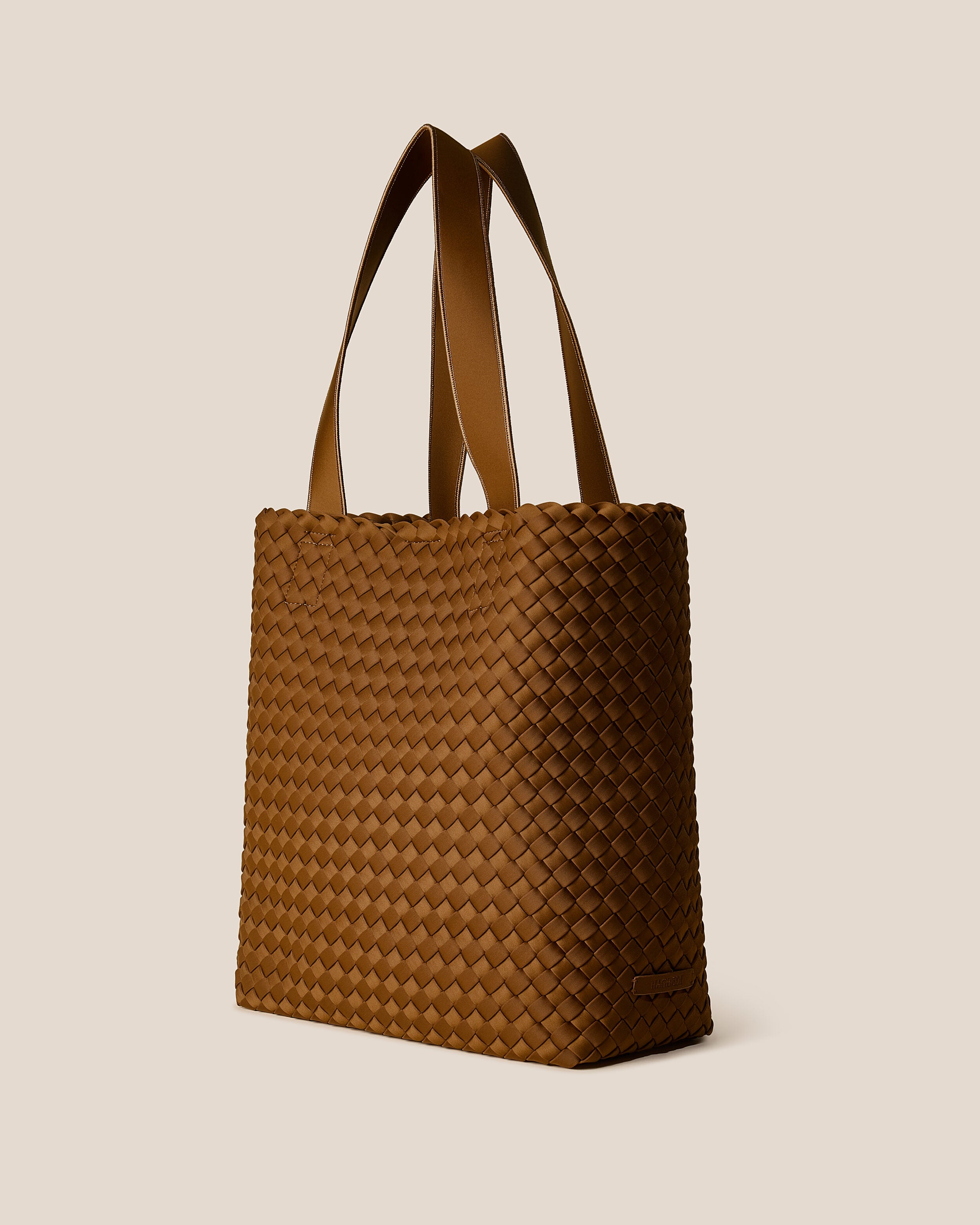 Como Tote in Teak shown from a side angle, highlighting its handwoven neoprene construction and open top with magnetic snap closure.