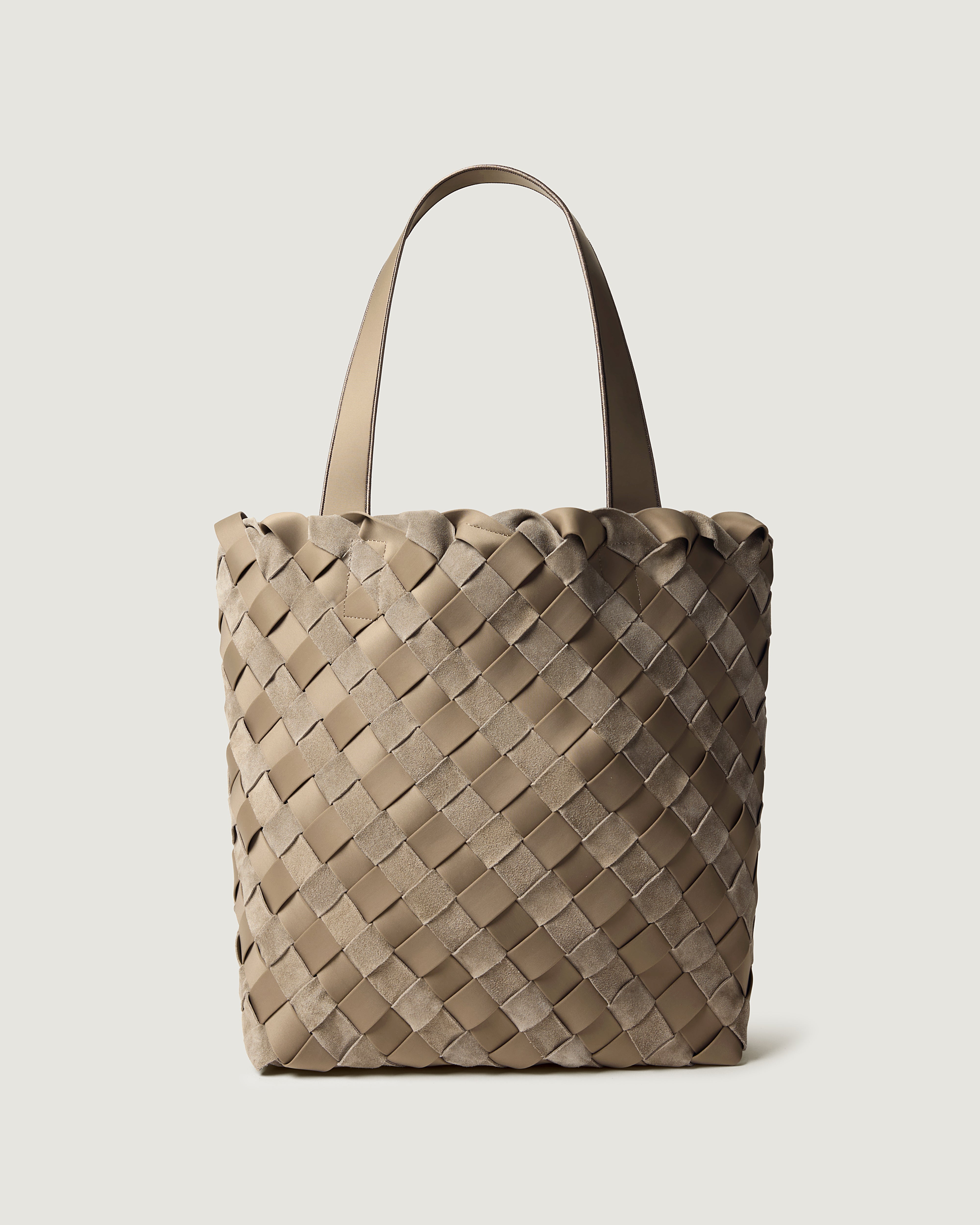 A handwoven suede and neoprene  tote bag in a taupe-beige color, featuring a basketweave pattern and two matching shoulder straps.