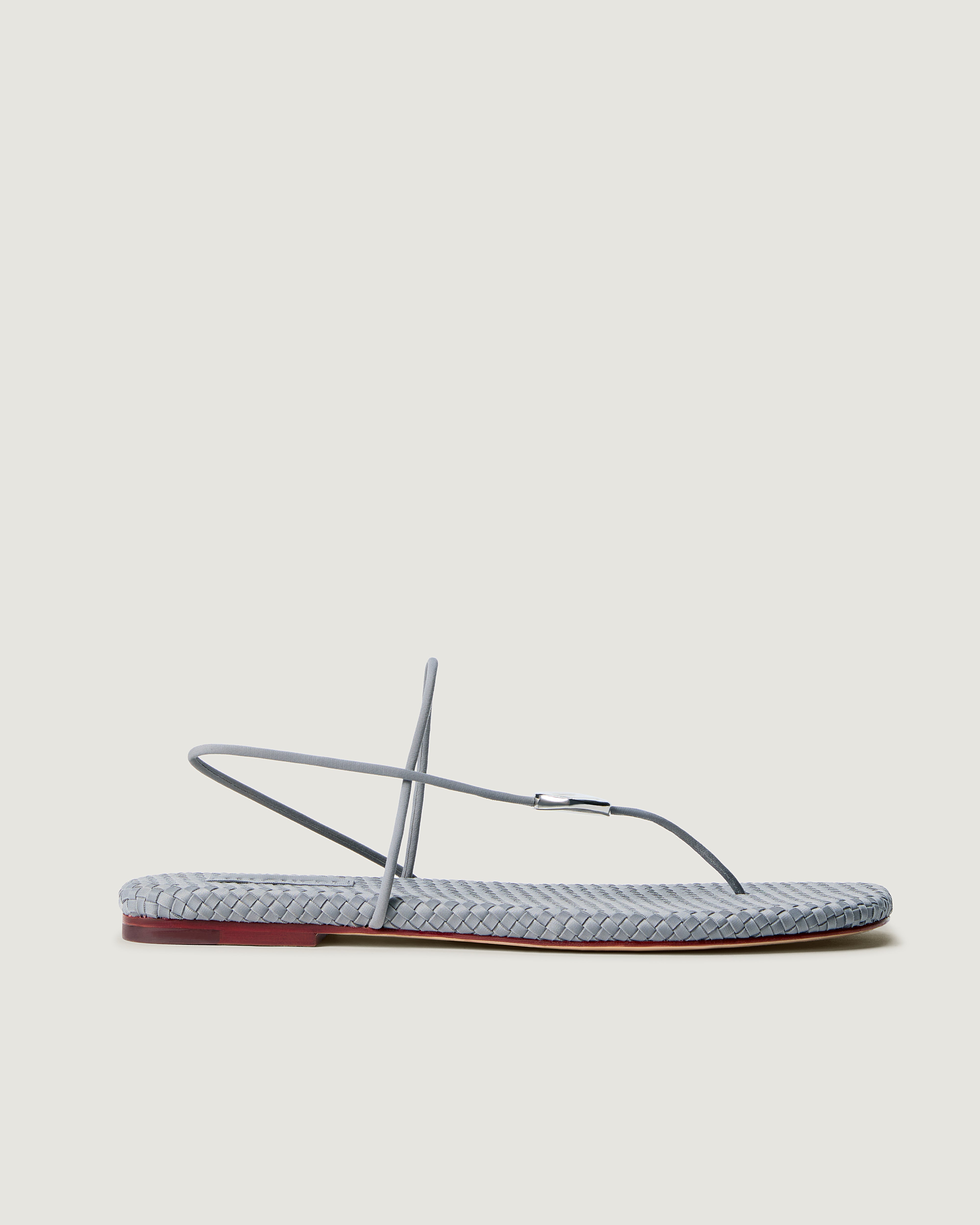 Side view of Gaia Sandal in Marina, a grey blue tone, featuring 2 thin straps and hammered metallic disc detail.