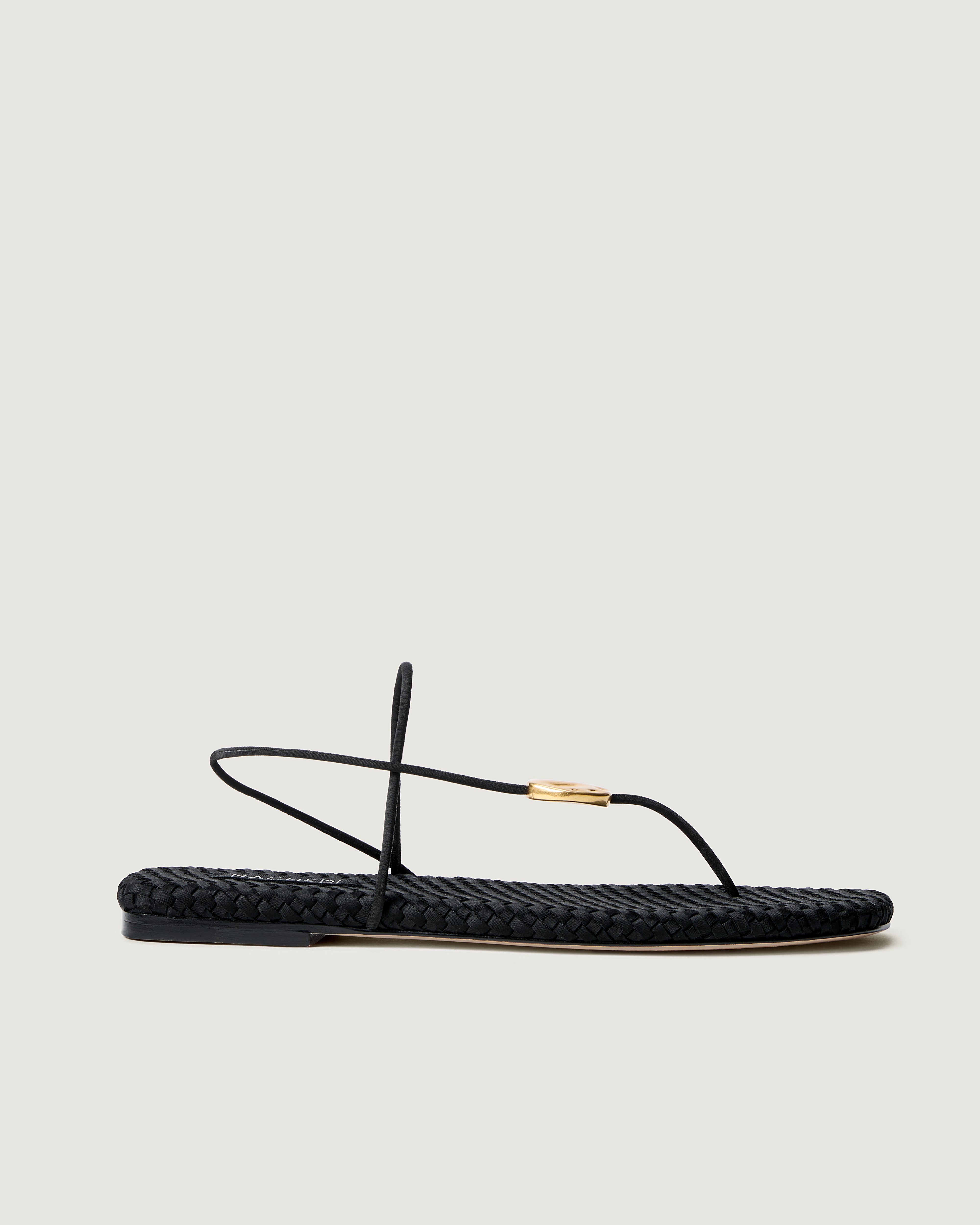 Side view of Gaia Sandal in Onyx, a true black tone, featuring 2 thin straps and hammered metallic disc detail.