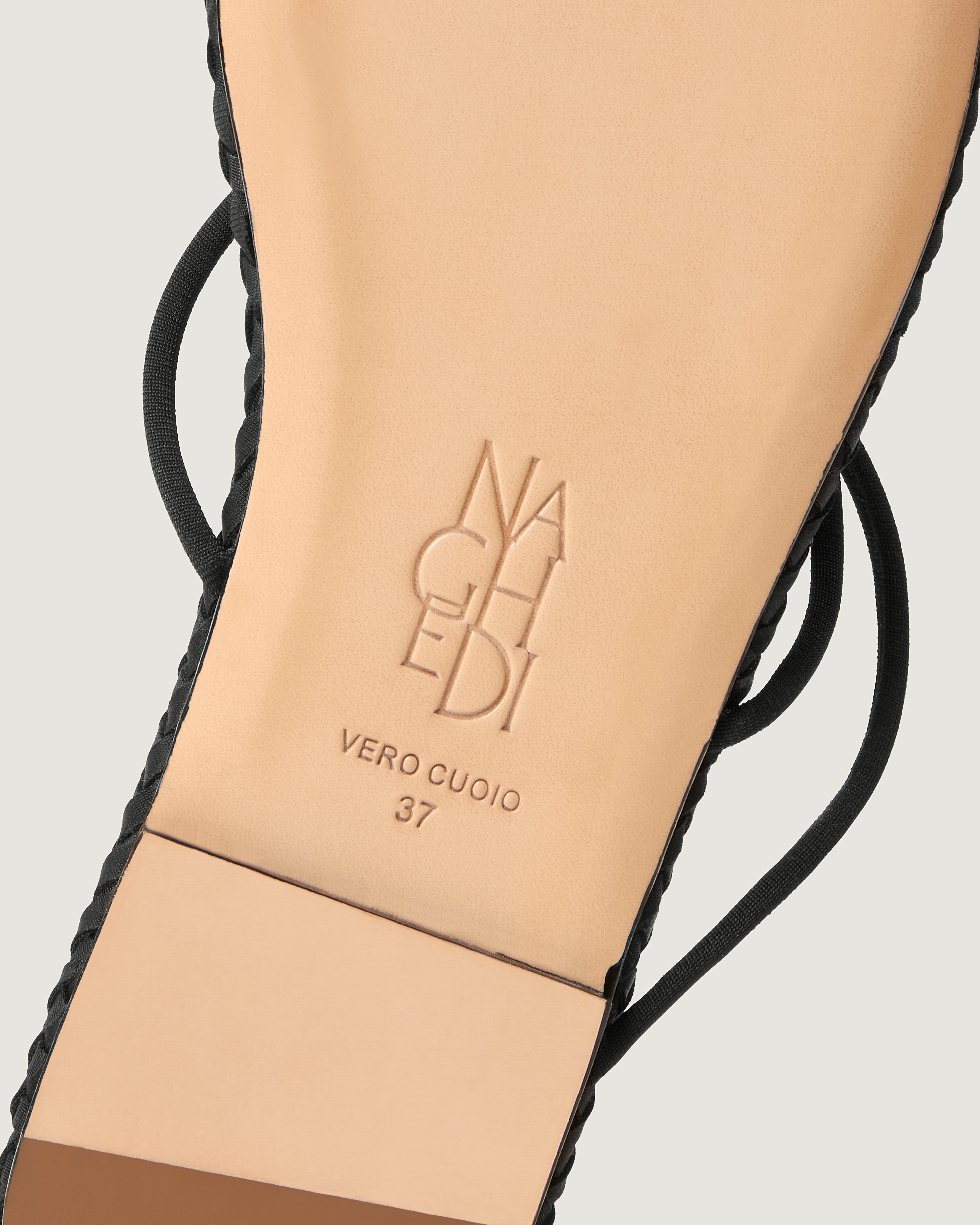 Shoe sole showing natural buffed leather sole, stamped NAGHEDI logo and size detail for Gaia Sandal in Onyx.