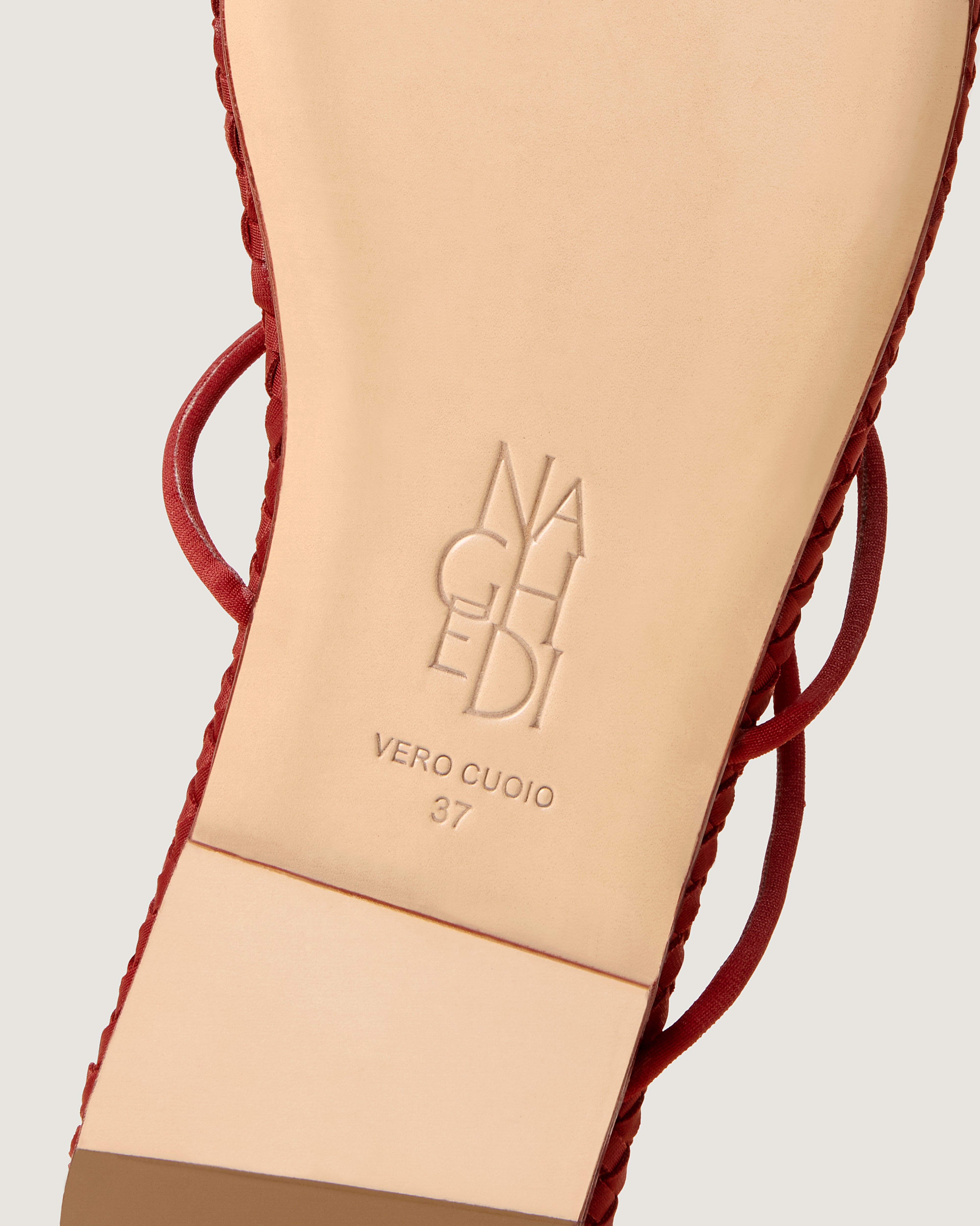 Shoe sole showing natural buffed leather sole, stamped NAGHEDI logo and size detail for Gaia Sandal in Rosso.