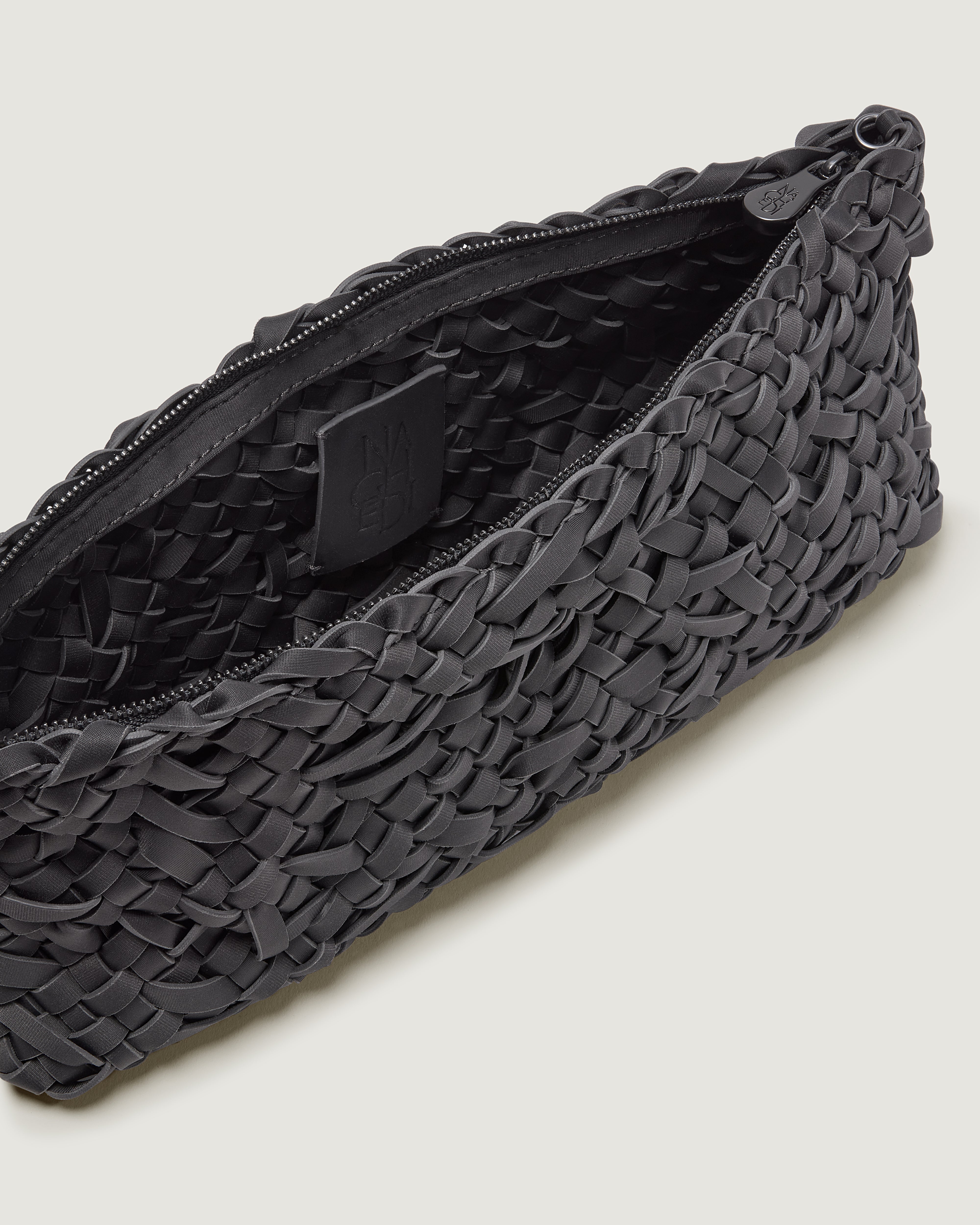 Close up of interior of handwoven neoprene shoulder bag in ash gray color with a crosshatch nest weave pattern and silver hardware