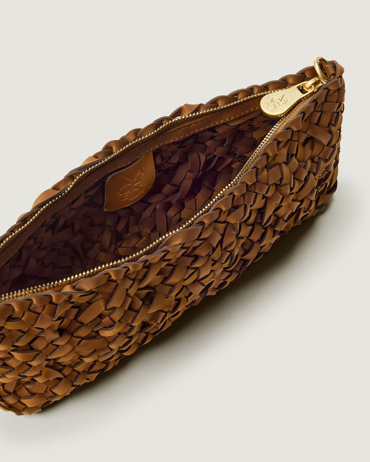 Close up of interior of Gala Clutch in handwoven neoprene in saddle brown color with a crosshatch nest weave pattern and gold hardware