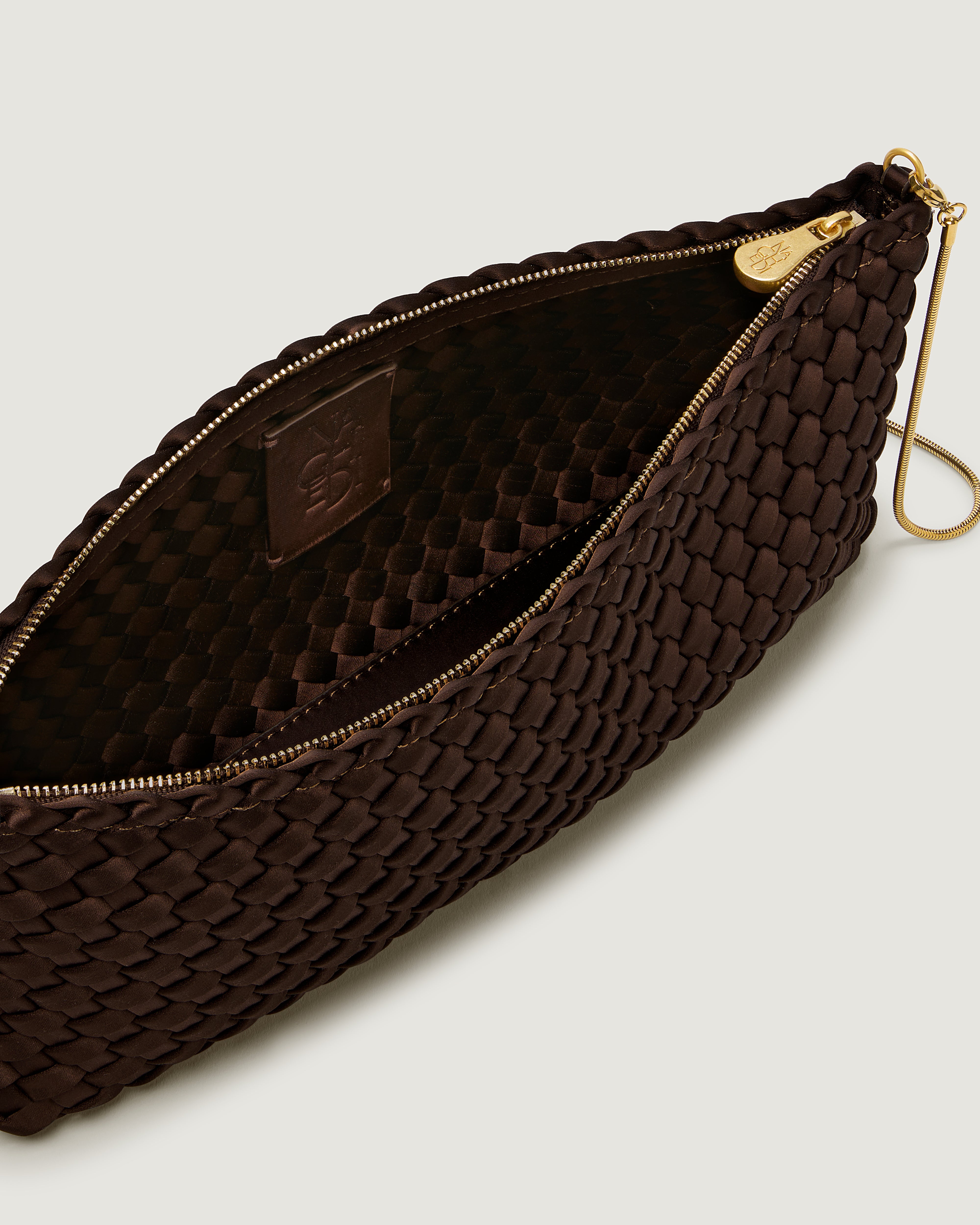 An interior shot of a handwoven satin neoprene shoulder bag in chocolate brown with a thin gold metal chain strap.