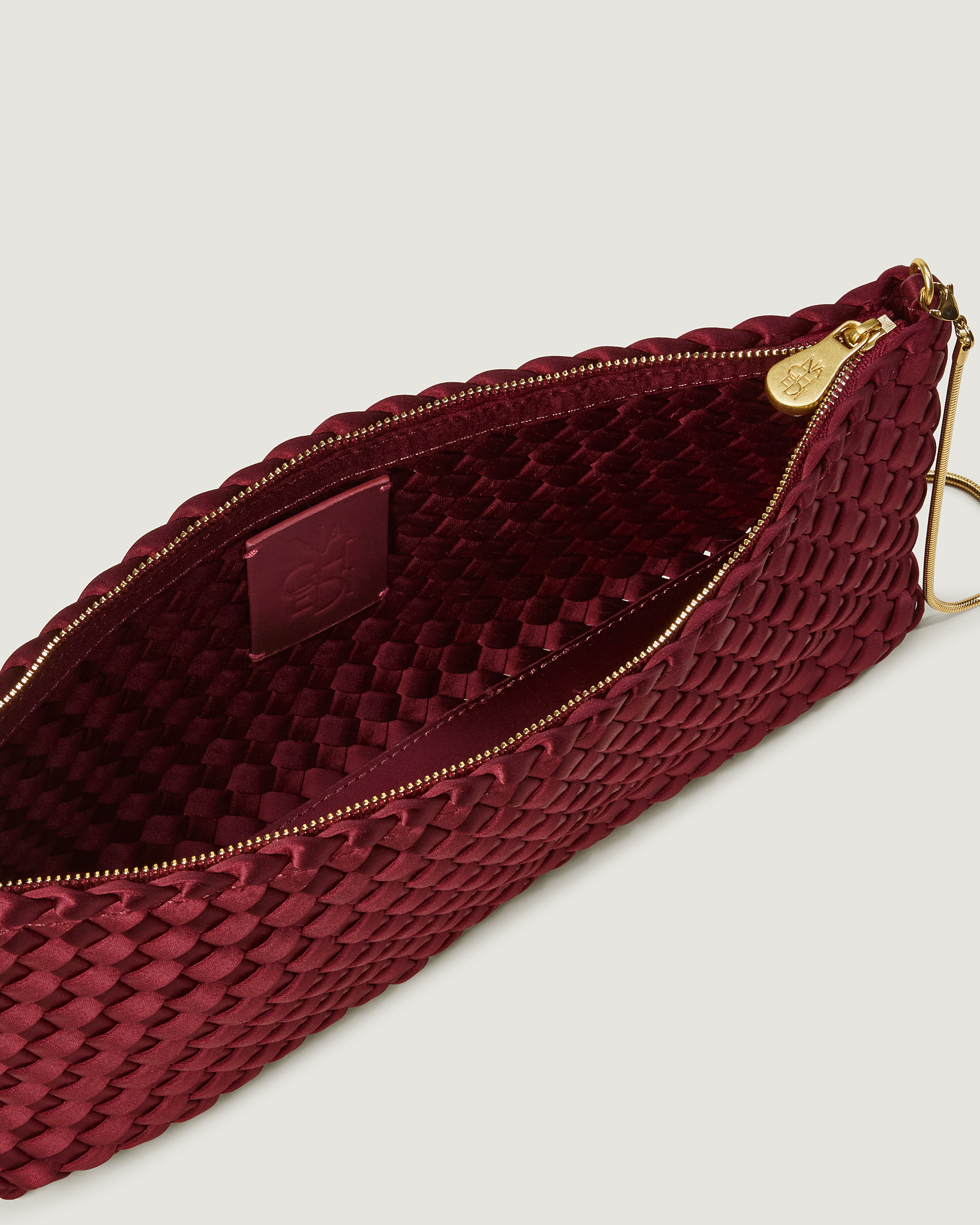 Interior close-up of Gala Clutch in Garnet showing its top zip closure.