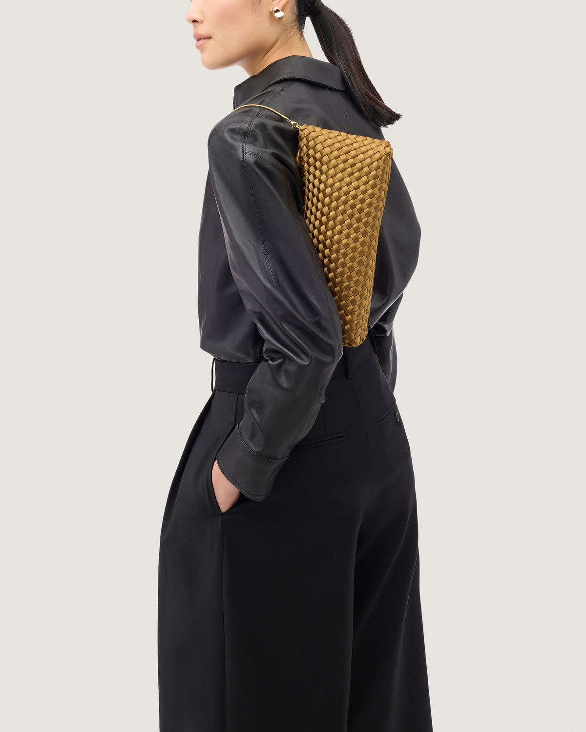 On model close up of the Gala Clutch in Luce Highlighting the handwoven satin and the removable gold chain.
