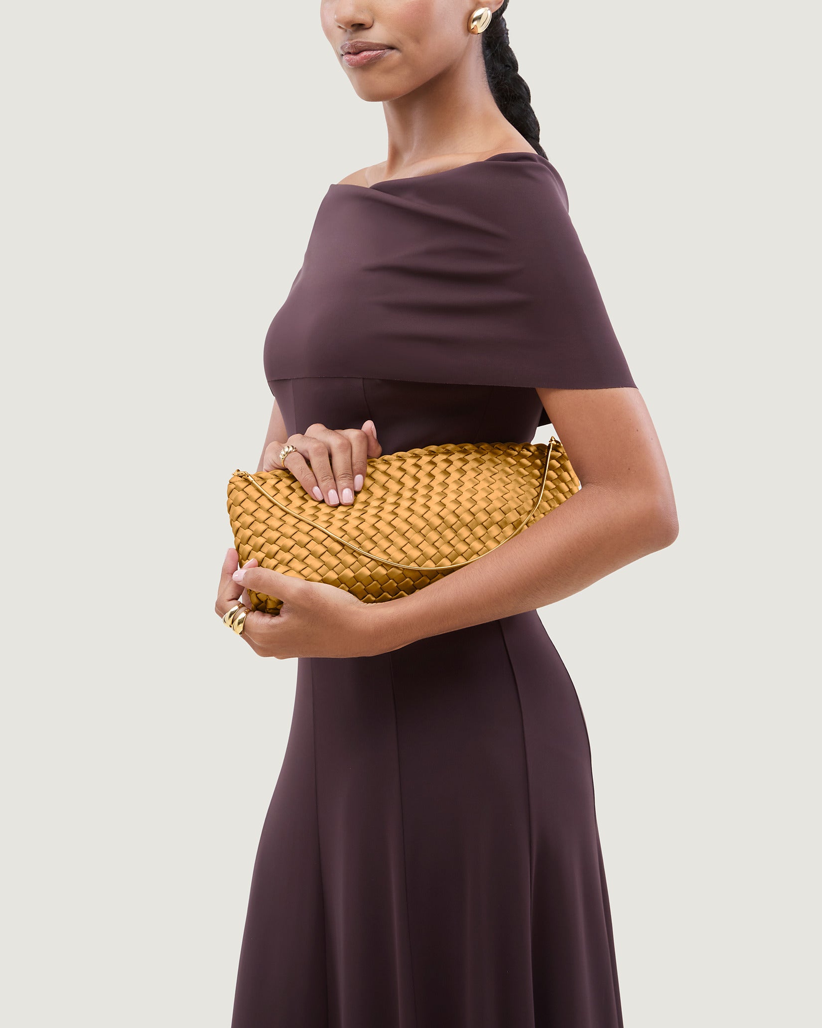 Gala Medium Satin Clutch Bag in Ore shown on model to illustrate scale and soft silhouette.