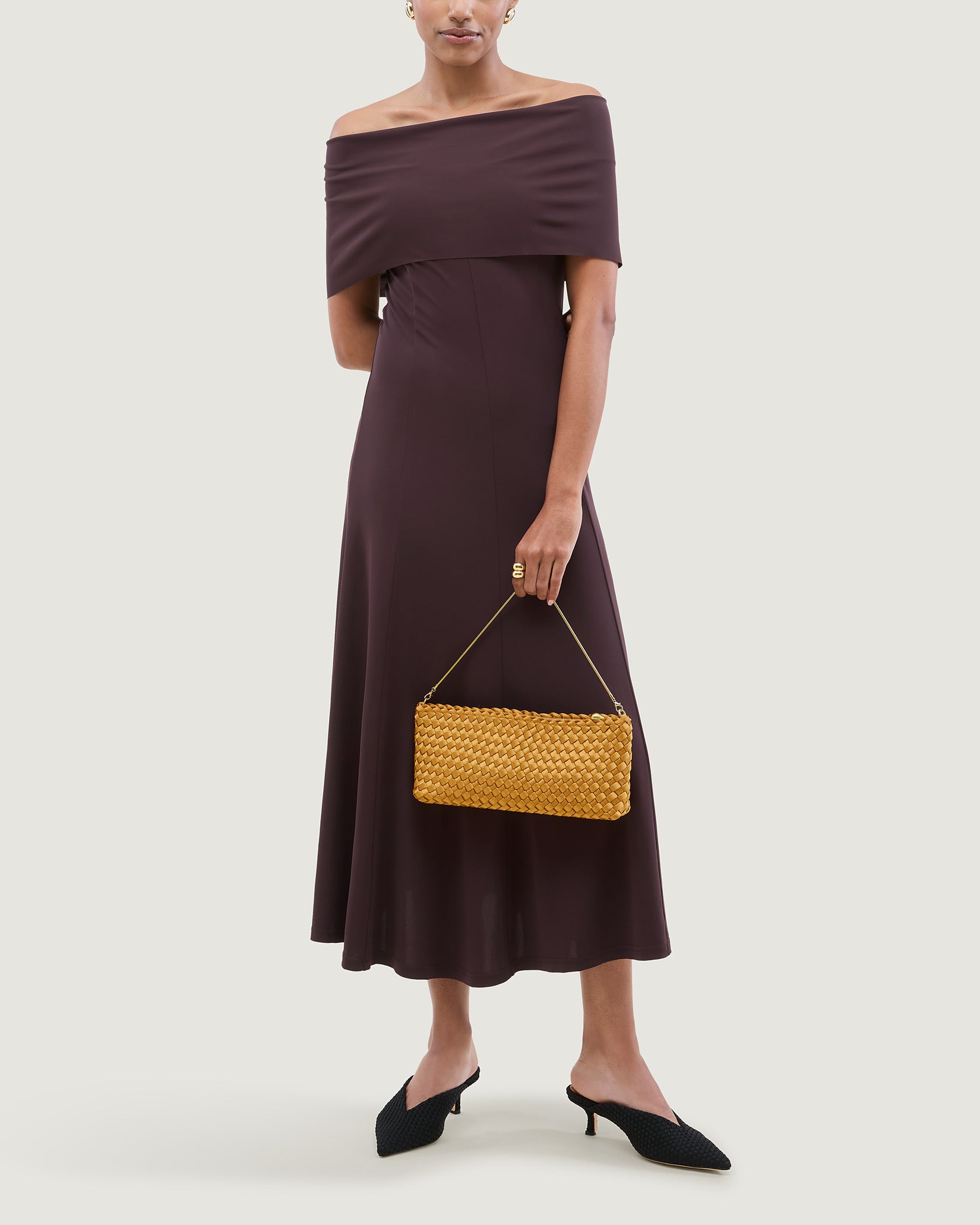 Gala Medium Satin Clutch Bag in Ore shown on model to illustrate scale and soft silhouette.