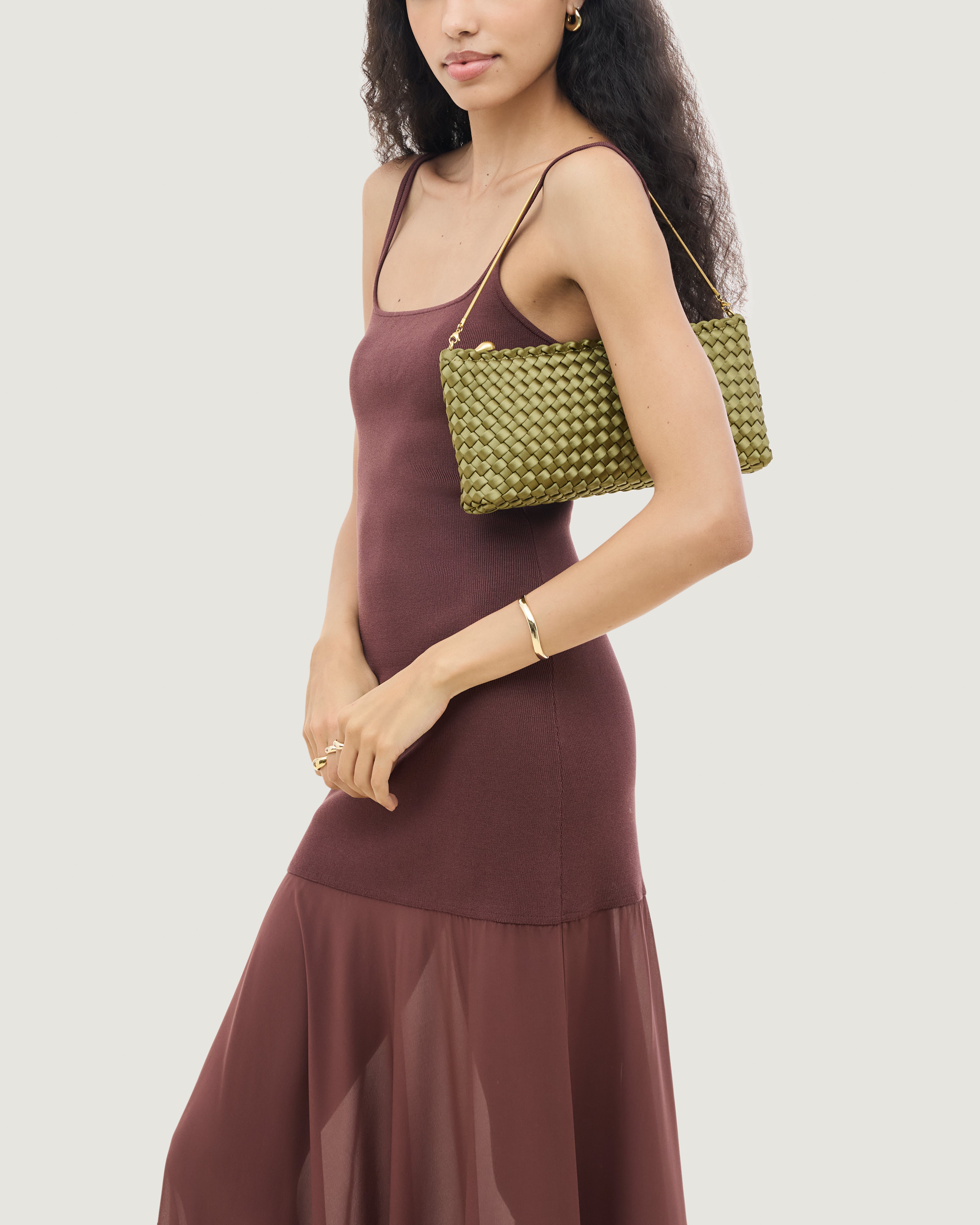 On model close up of the Gala Clutch in Peridot. Highlighting the handwoven satin and the removable gold chain.