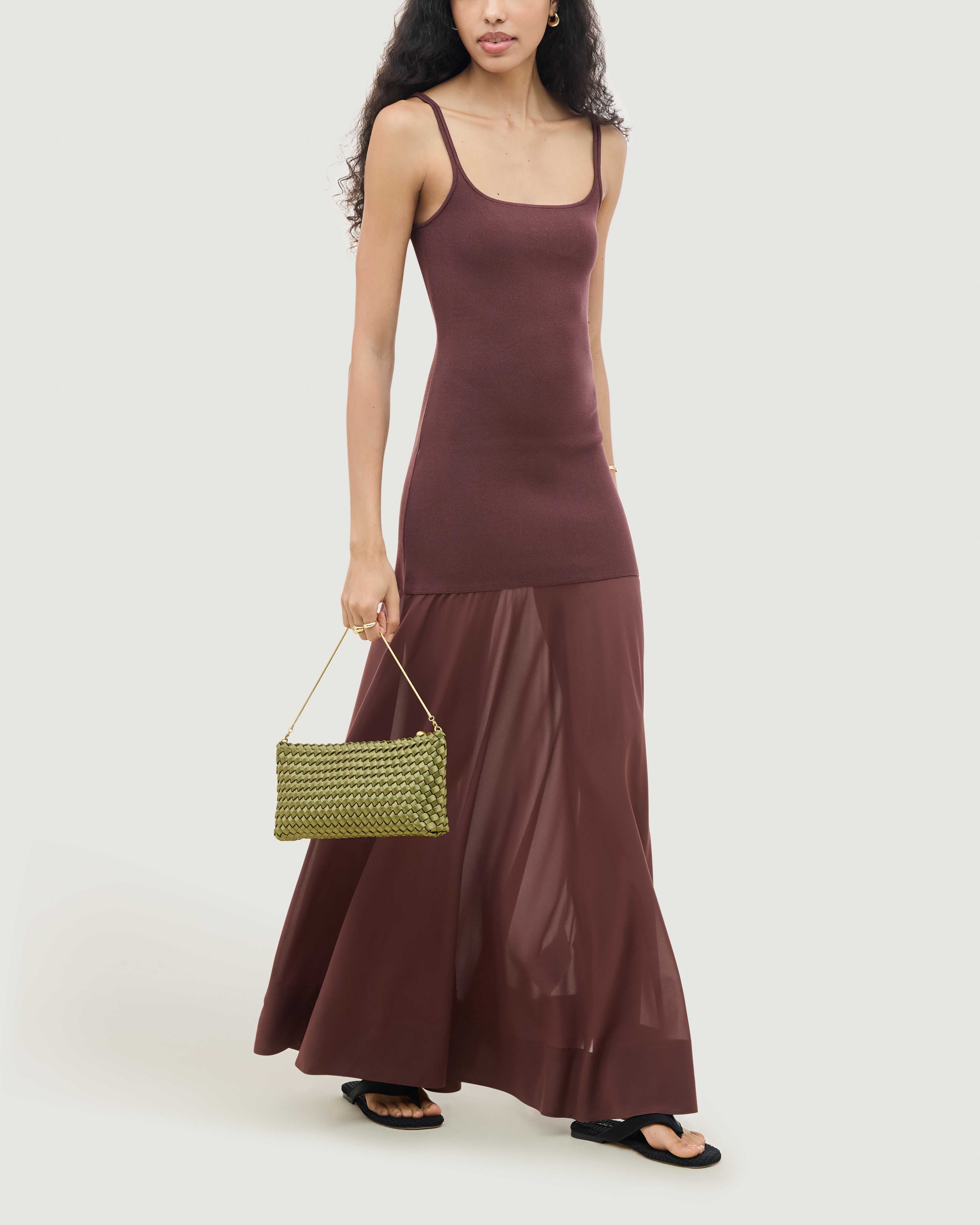 On model close up of the Gala Clutch in Peridot. Highlighting the handwoven satin and the removable gold chain.