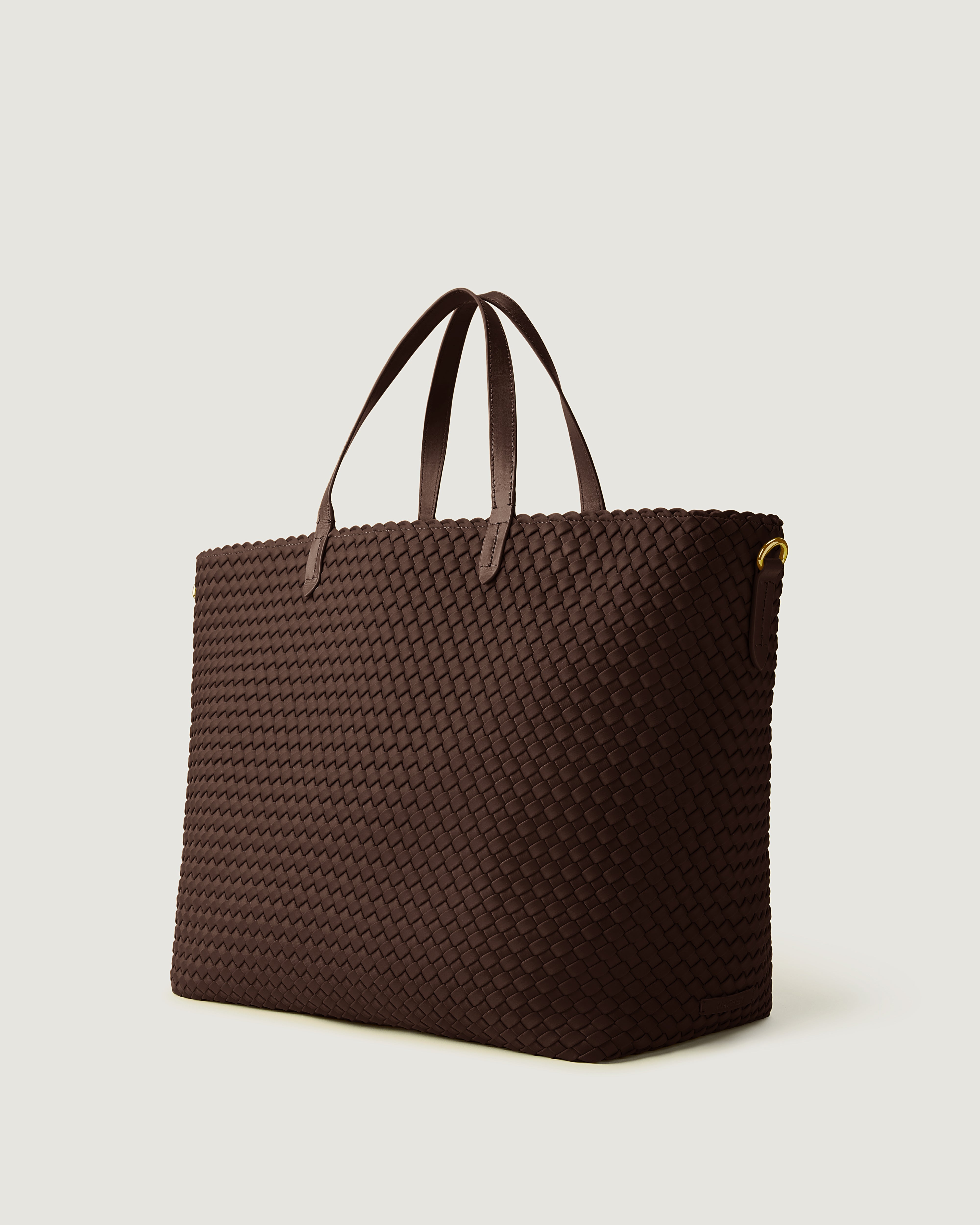 Geneva Weekender in Chocolate shown from a side angle, highlighting its handwoven neoprene construction and leather handles.