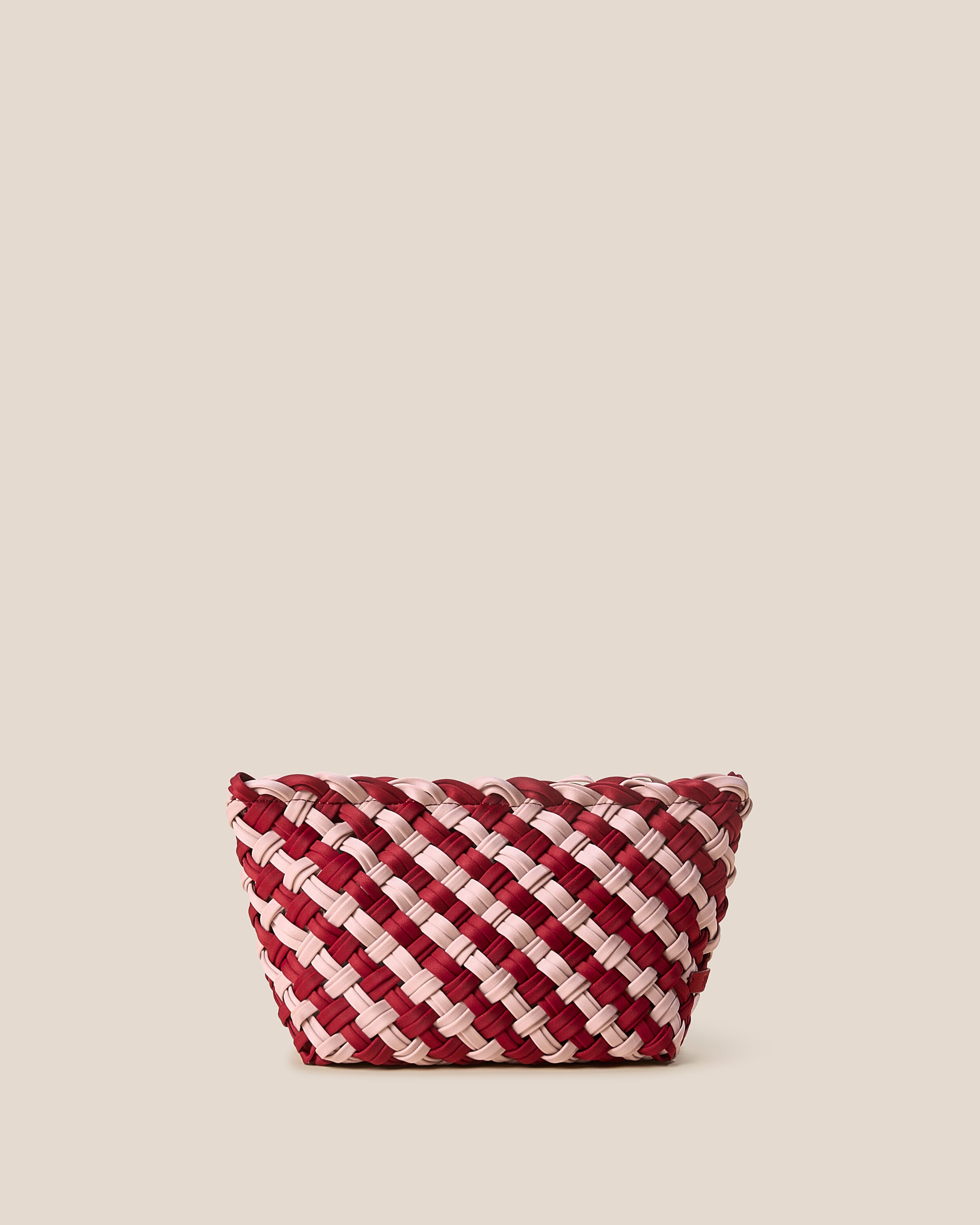 Gigi Clutch in Lychee, a rich red and soft ballet pink tone, in handwoven neoprene, featuring a top zip closure.