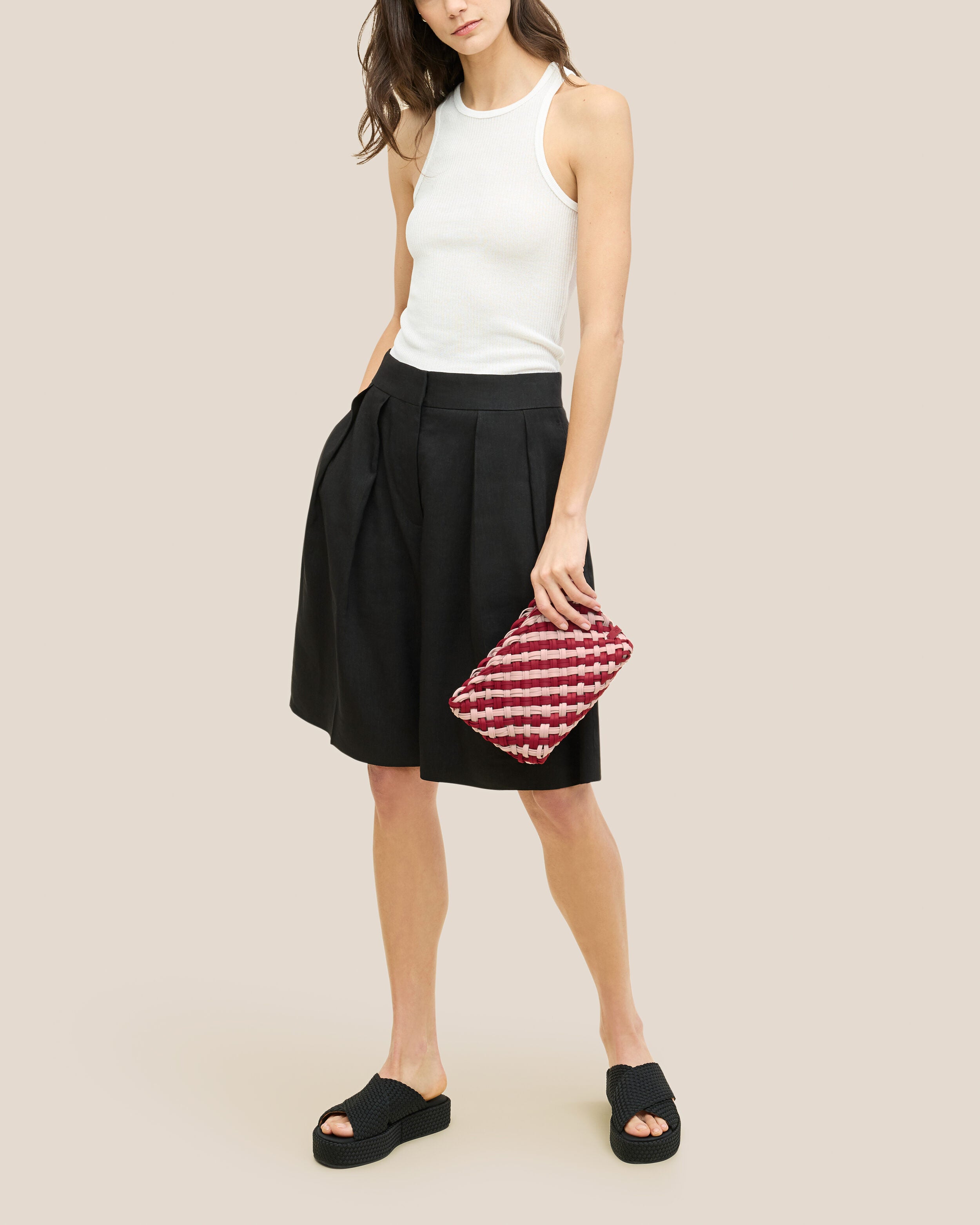 Gigi Clutch in Lychee shown on model to illustrate scale and soft silhouette.