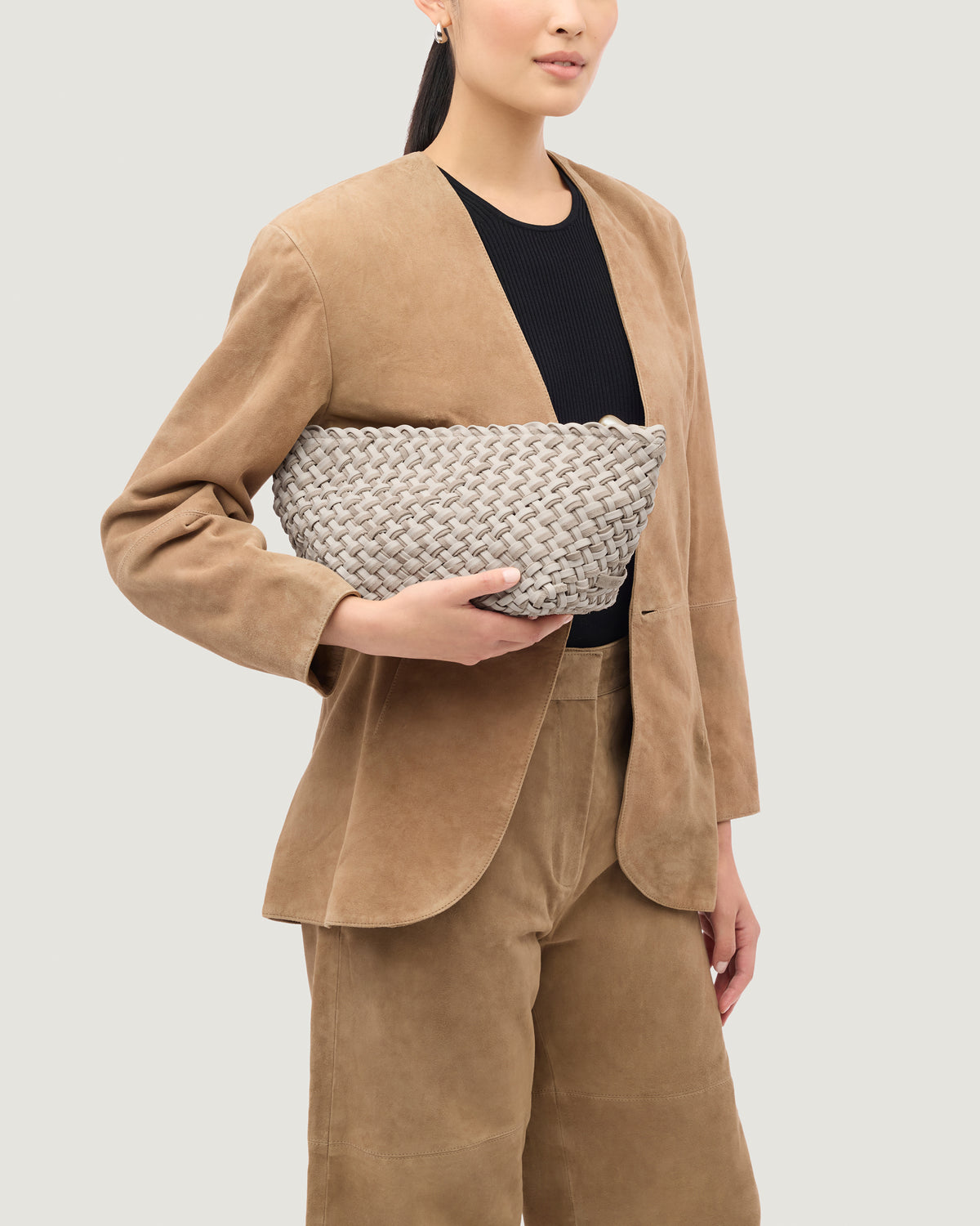 Gigi Large Clutch in Linen shown on model to illustrate size and soft silhouette
