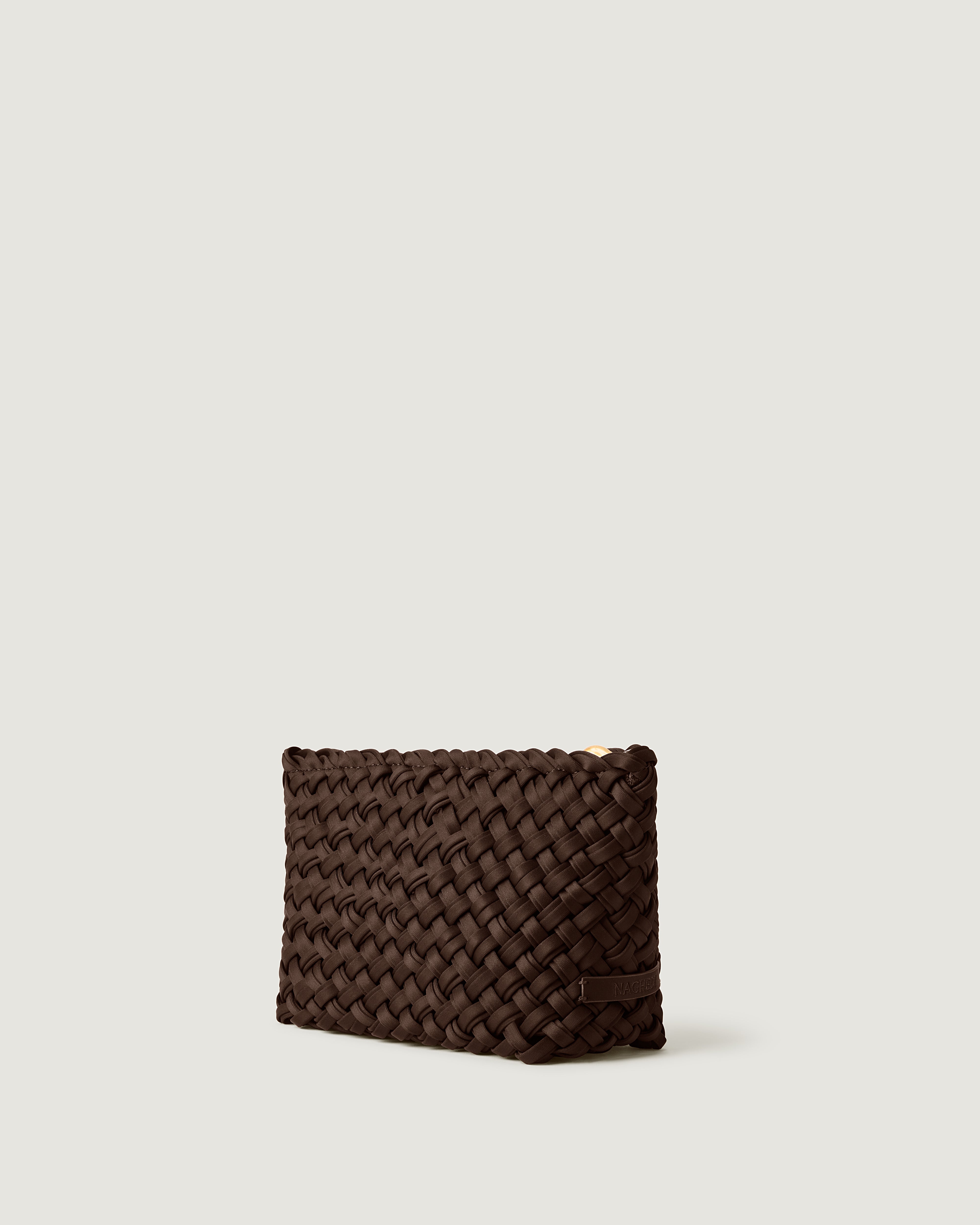 Gigi Clutch in Chocolate shown from a side angle, highlighting its handwoven neoprene construction and top zip closure.