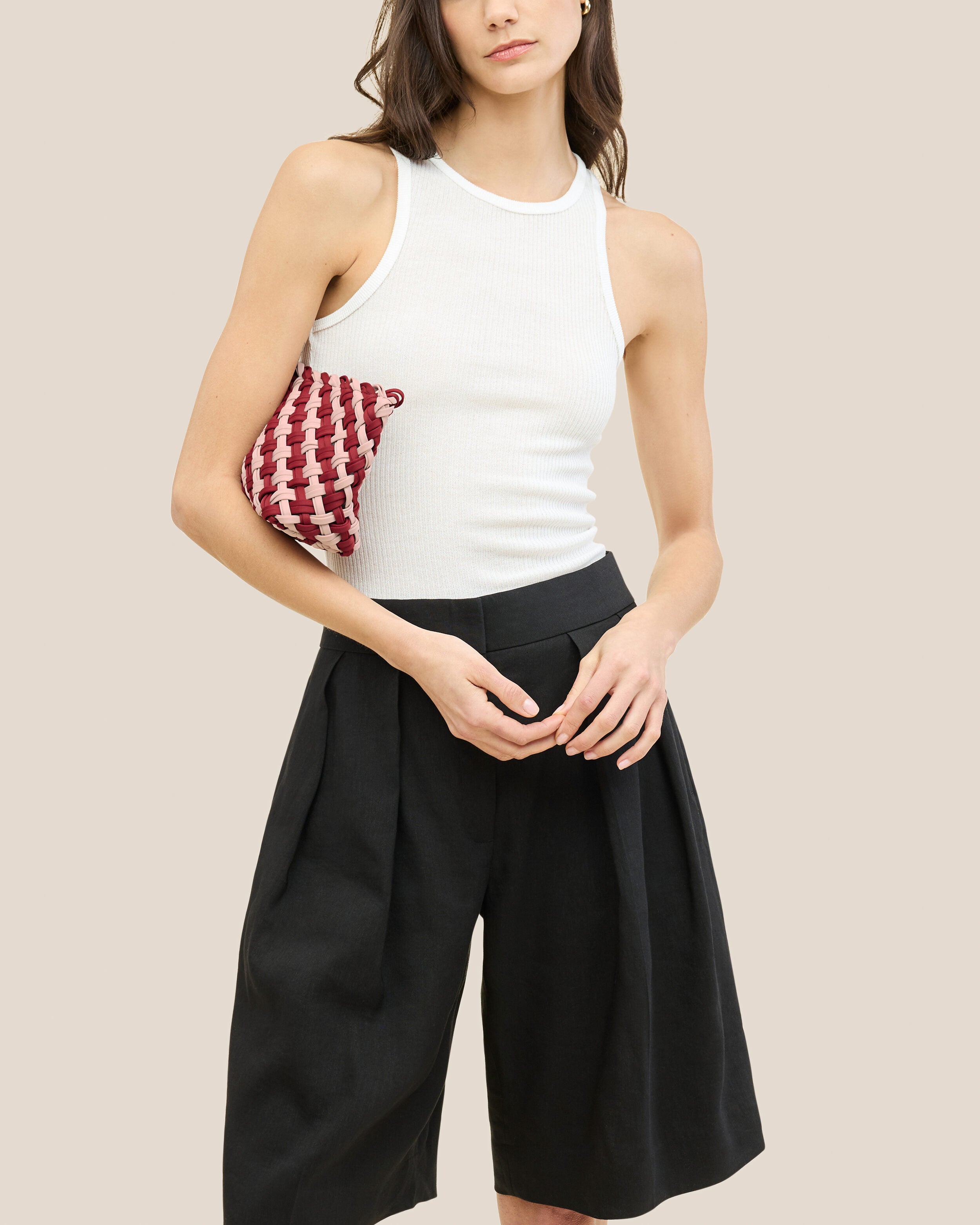 Gigi Clutch in Lychee shown on model to illustrate scale and soft silhouette.