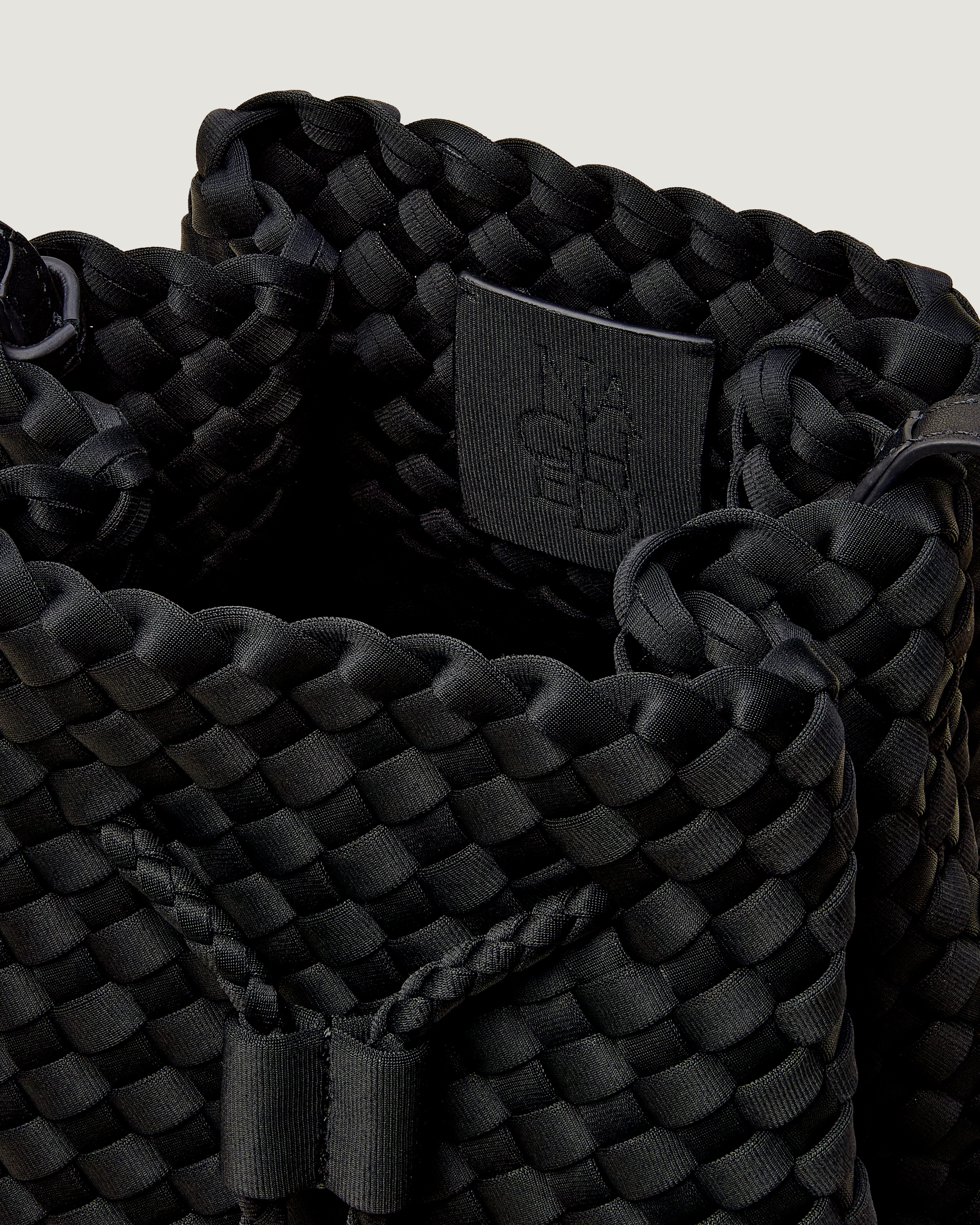Interior close-up of Gramercy Bucket in Onyx showing its drawstring closure, and unlined interior.