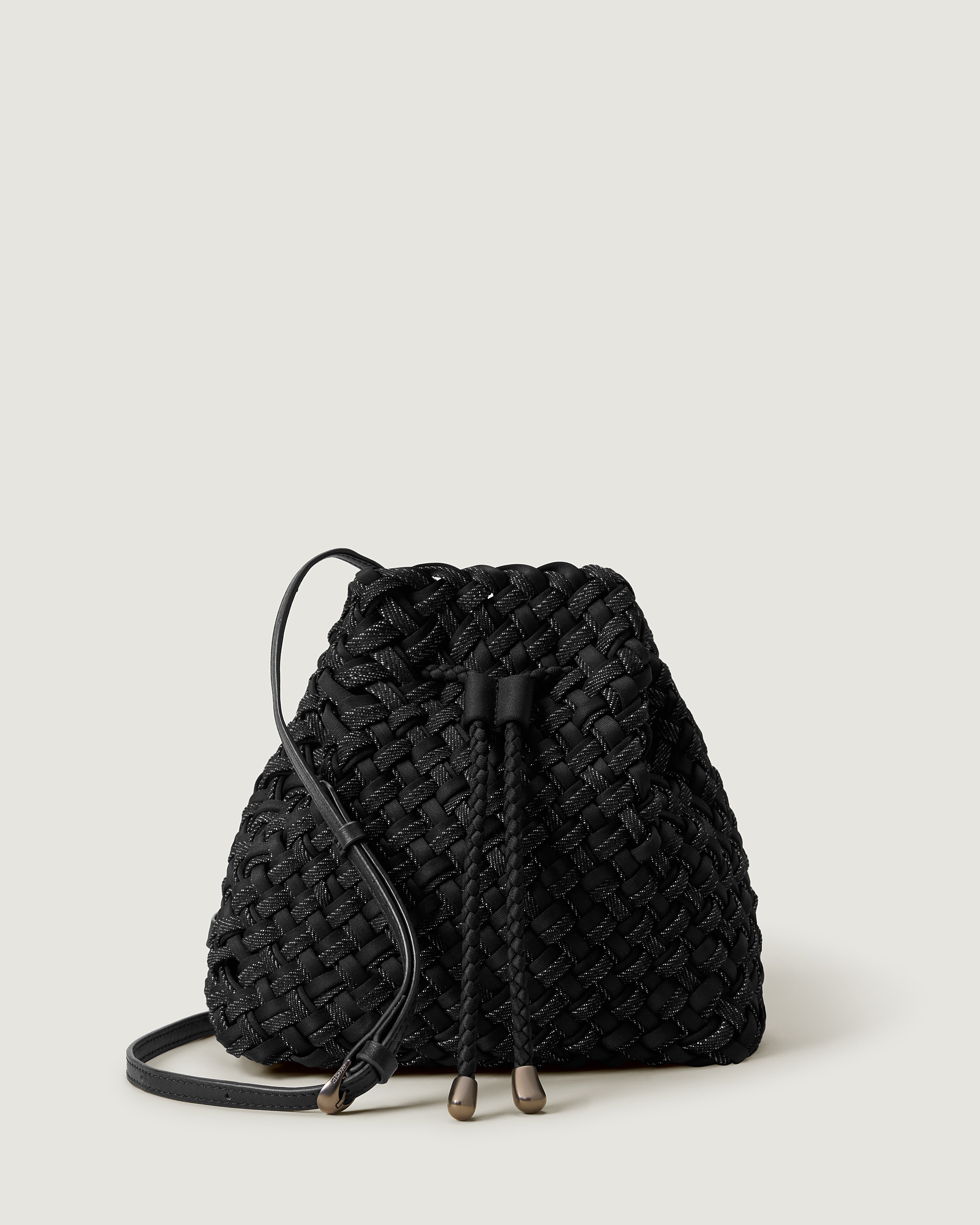 Gramercy Bucket in Jet, handwoven from doubled strands of black denim with black neoprene. Featuring a drawstring closure, and adjustable leather crossbody strap.