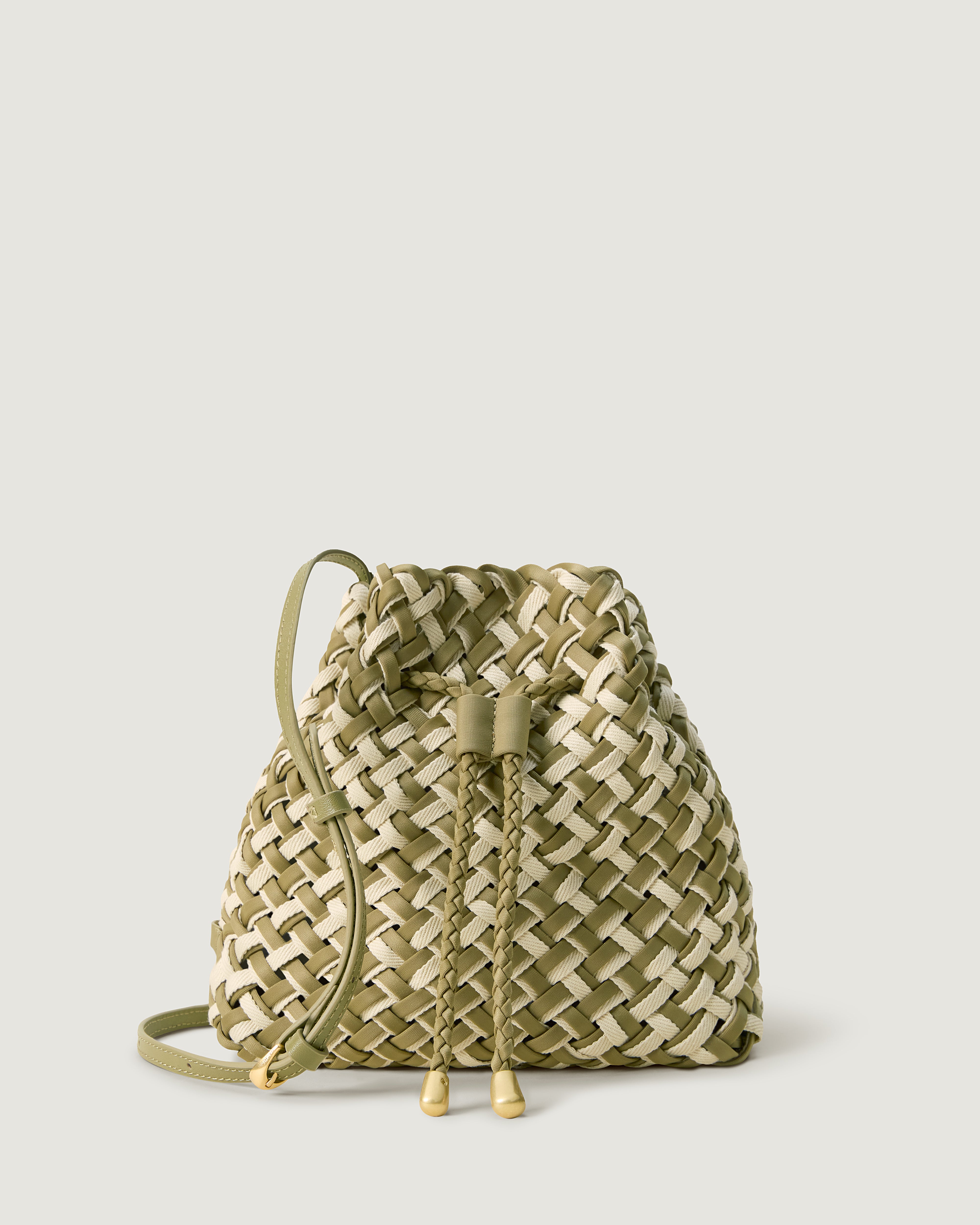 Gramercy Bucket in Oletta, handwoven from doubled strands of muted bottle green neoprene with cream cotton. Featuring a drawstring closure, and adjustable leather crossbody strap.