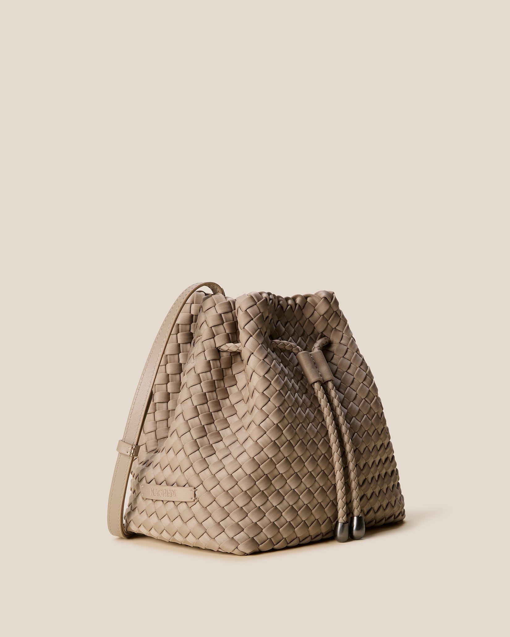 Gramercy Medium Bucket Bag in Cashmere shown from a side angle, highlighting its handwoven neoprene and drawstring closure.