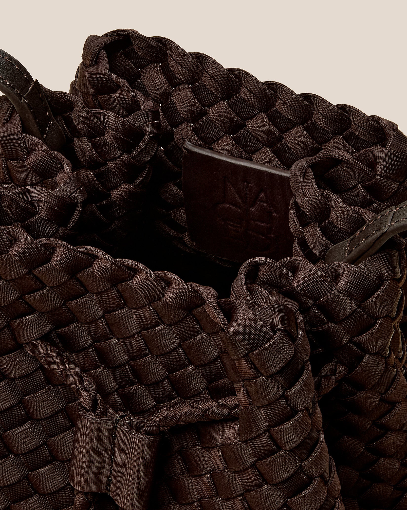 Interior close-up of Gramercy Medium Bucket Bag in Chocolate showing its drawstring closure, and unlined interior.