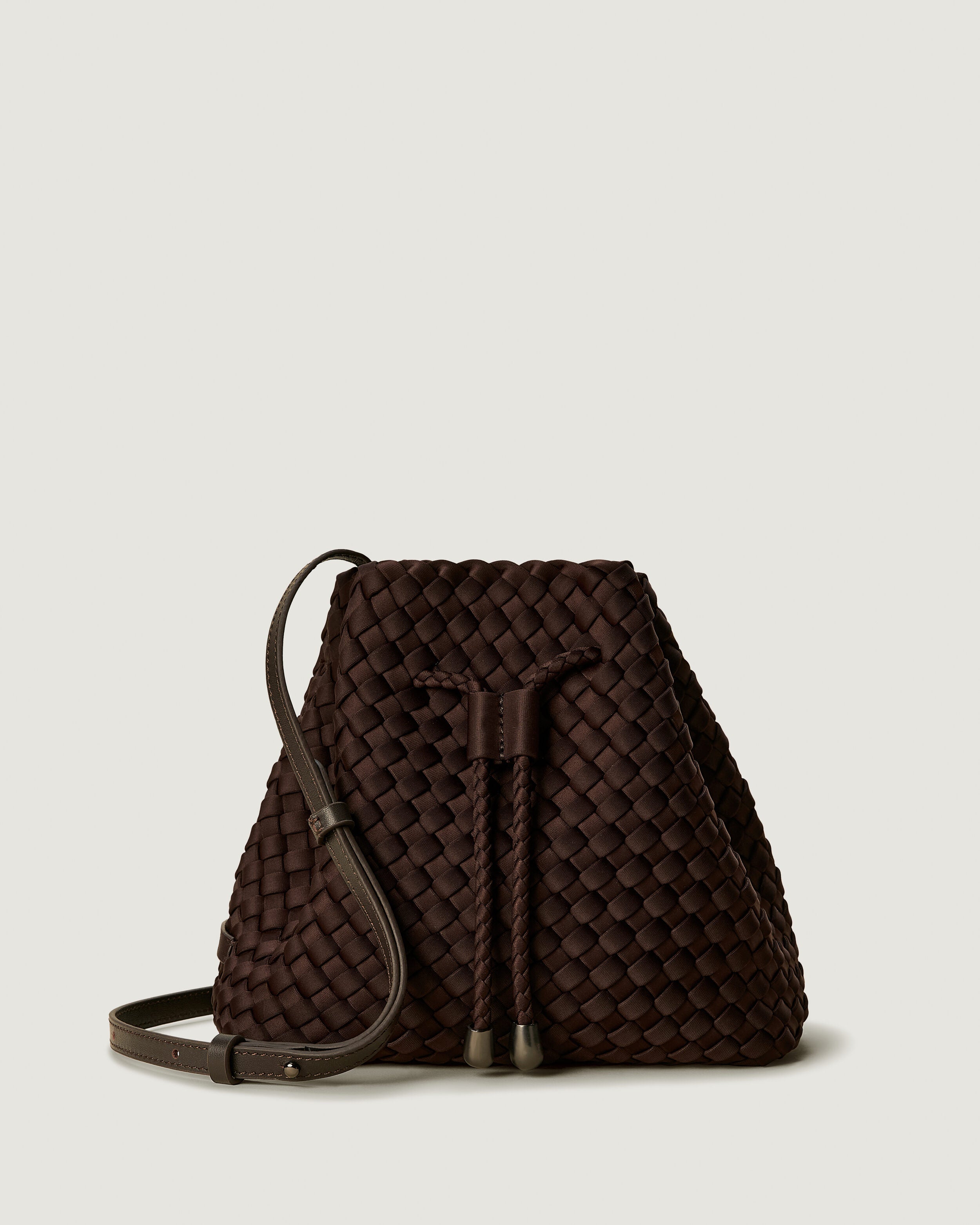 Gramercy Bucket in Chocolate, a dark chocolate brown tone, in handwoven neoprene, featuring a drawstring closure, and adjustable leather crossbody strap.