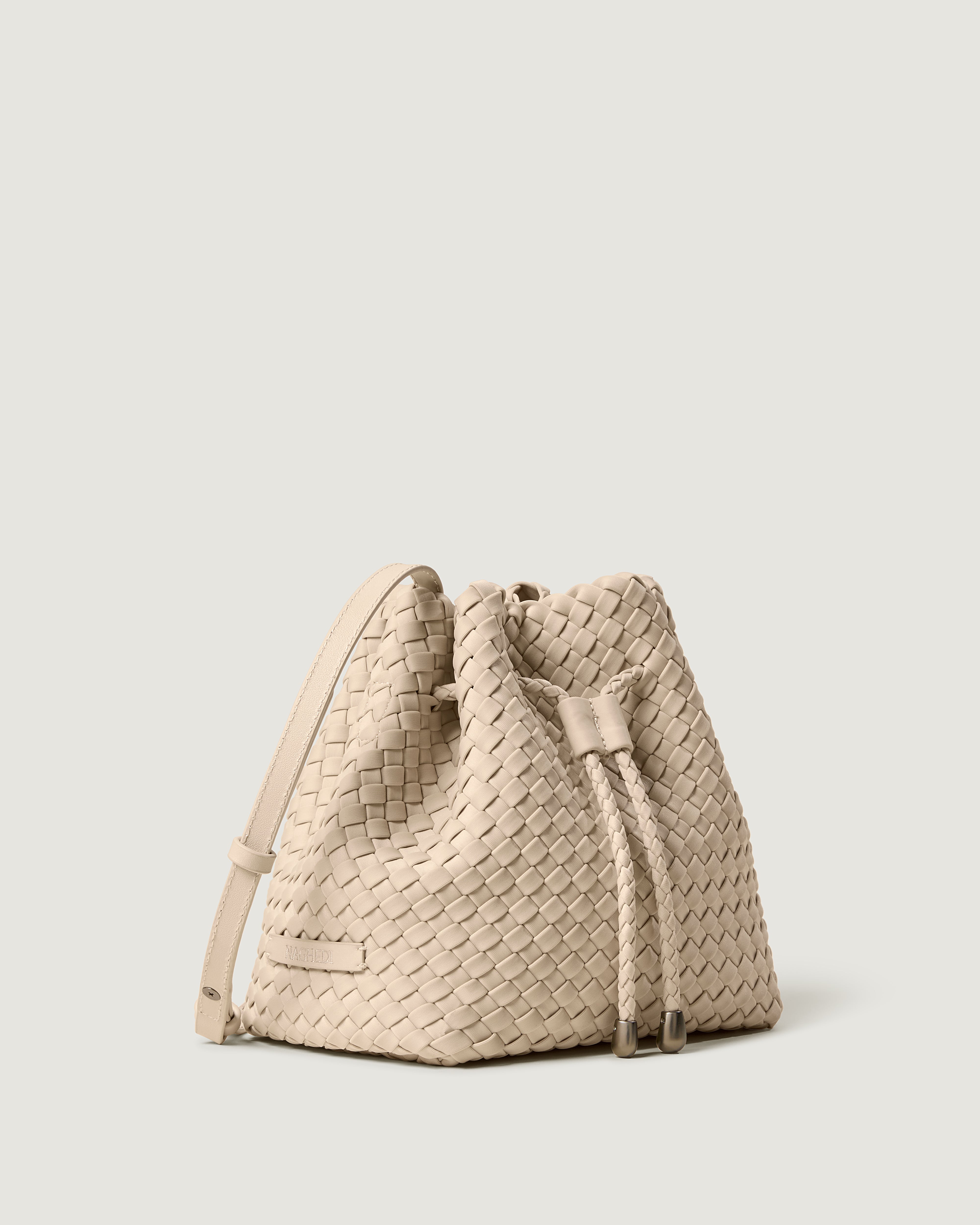 Gramercy Bucket in Ecru shown from a side angle, highlighting its handwoven neoprene construction and drawstring closure.
