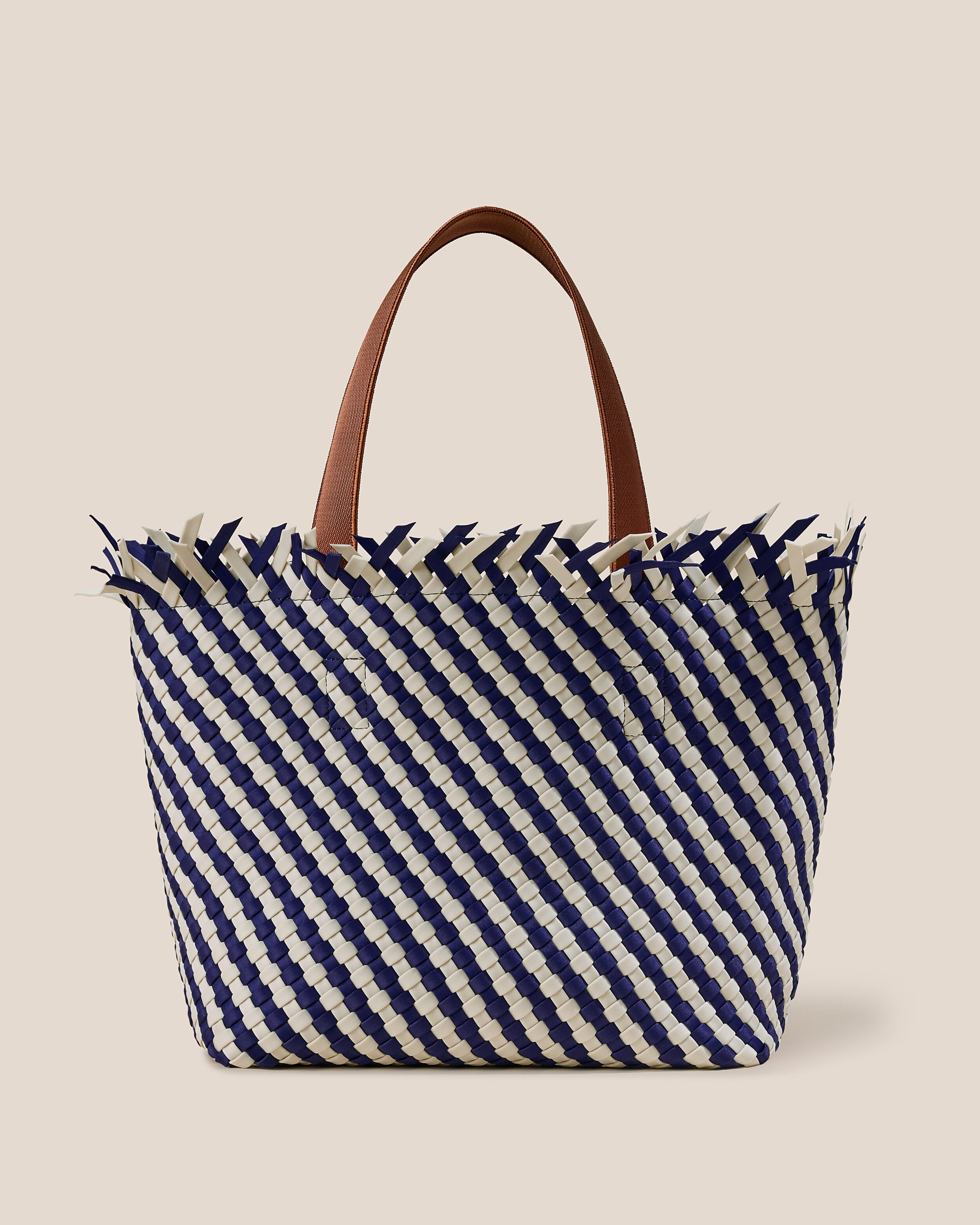 Havana  in Venice, a navy blue and dove white tone, in handwoven neoprene, featuring an open top with magnetic snap closure, and sleek nylon webbing handles fit over the shoulder.