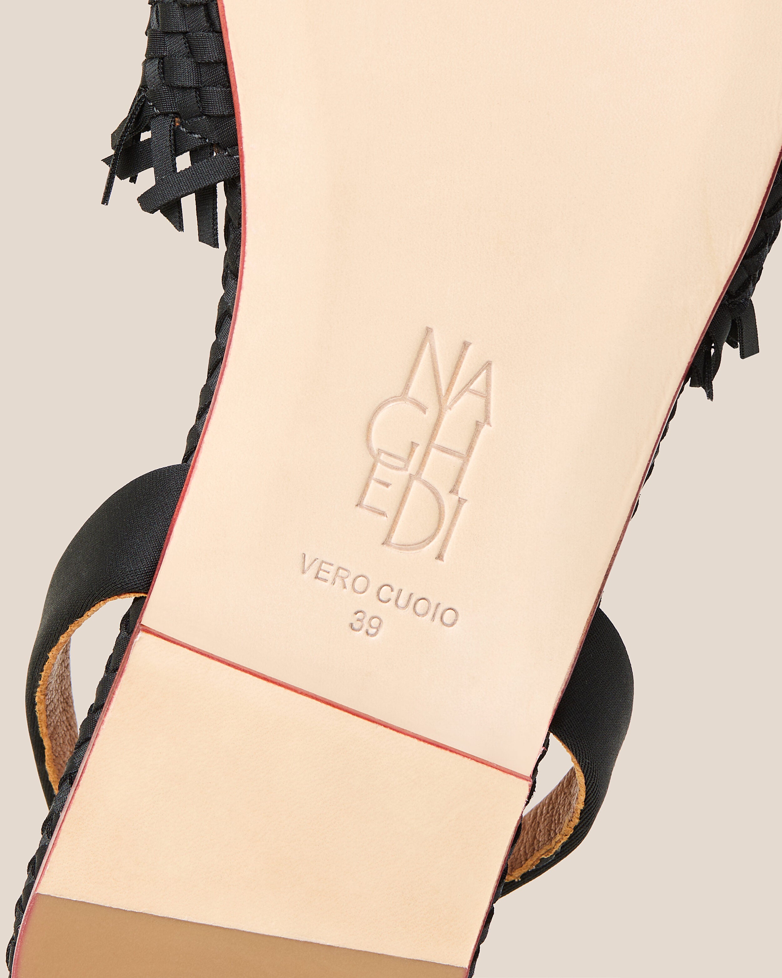 Shoe sole showing natural buffed leather sole, stamped NAGHEDI logo and size detail for The Havana Sandal in Onyx.