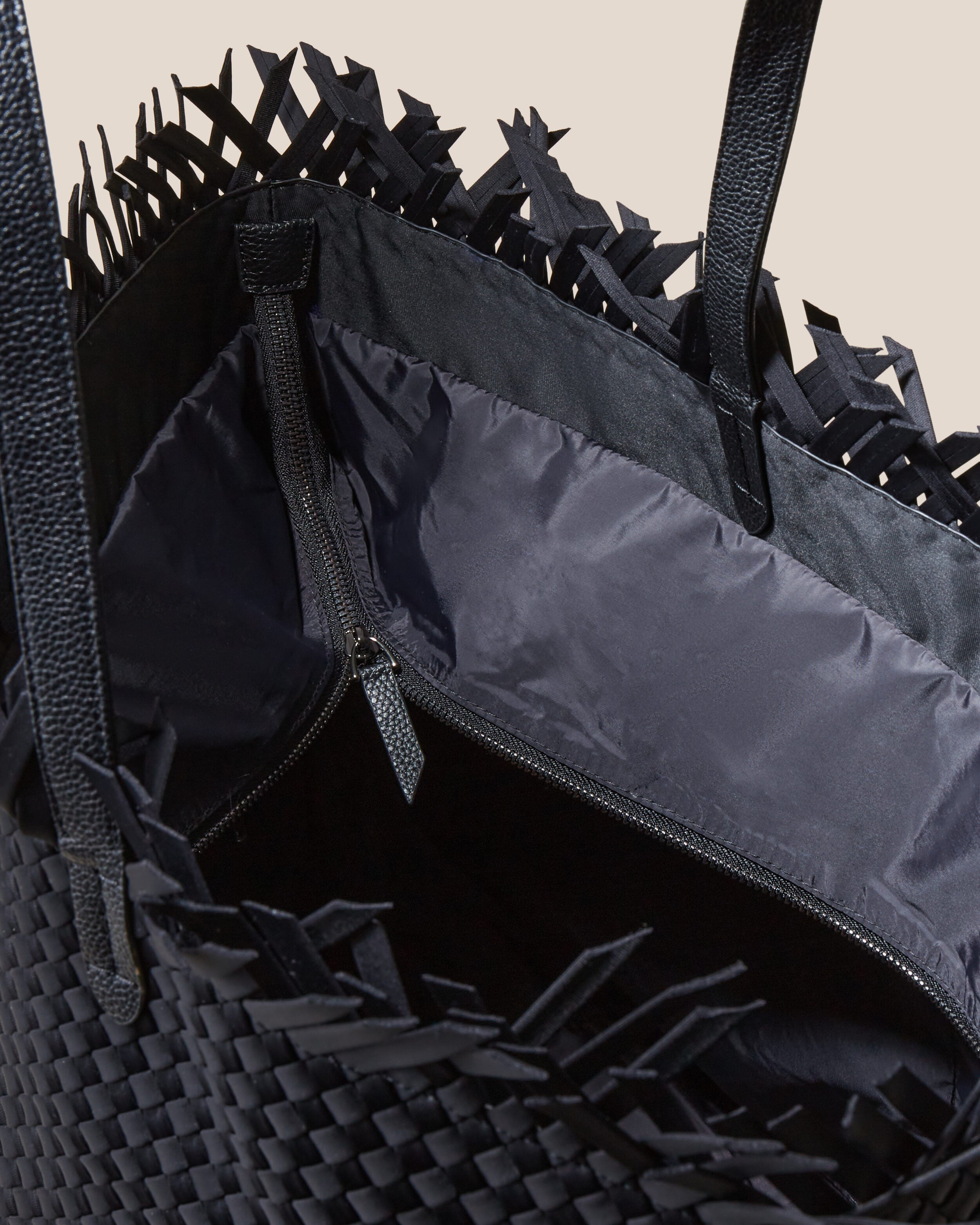 Interior close-up of Havana  in Onyx showing its top zip closure, interior pockets, and wipe-clean nylon interior.