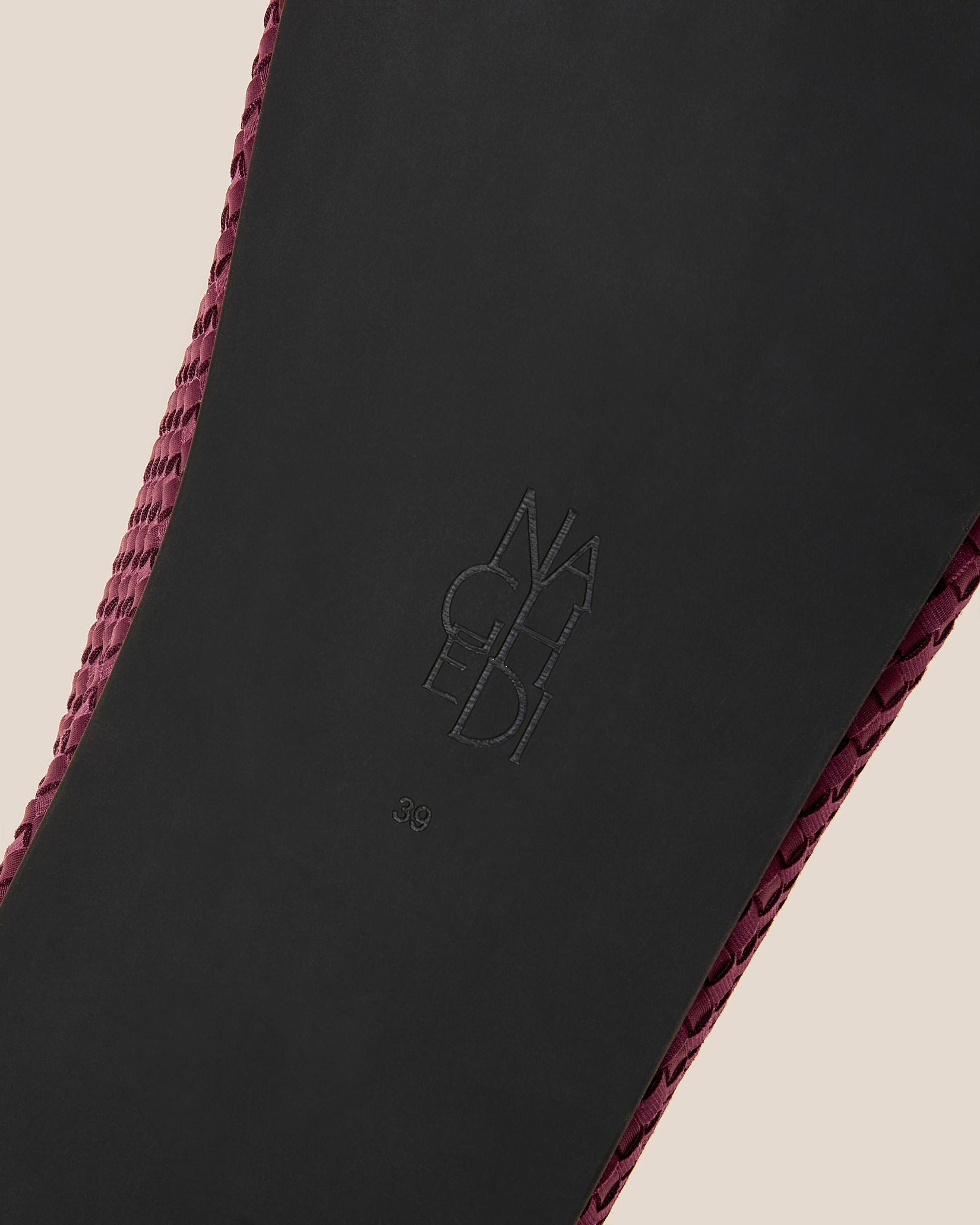 Shoe sole showing natural rubber sole, stamped NAGHEDI logo and size detail for Hudson Clogs in Bordeaux.