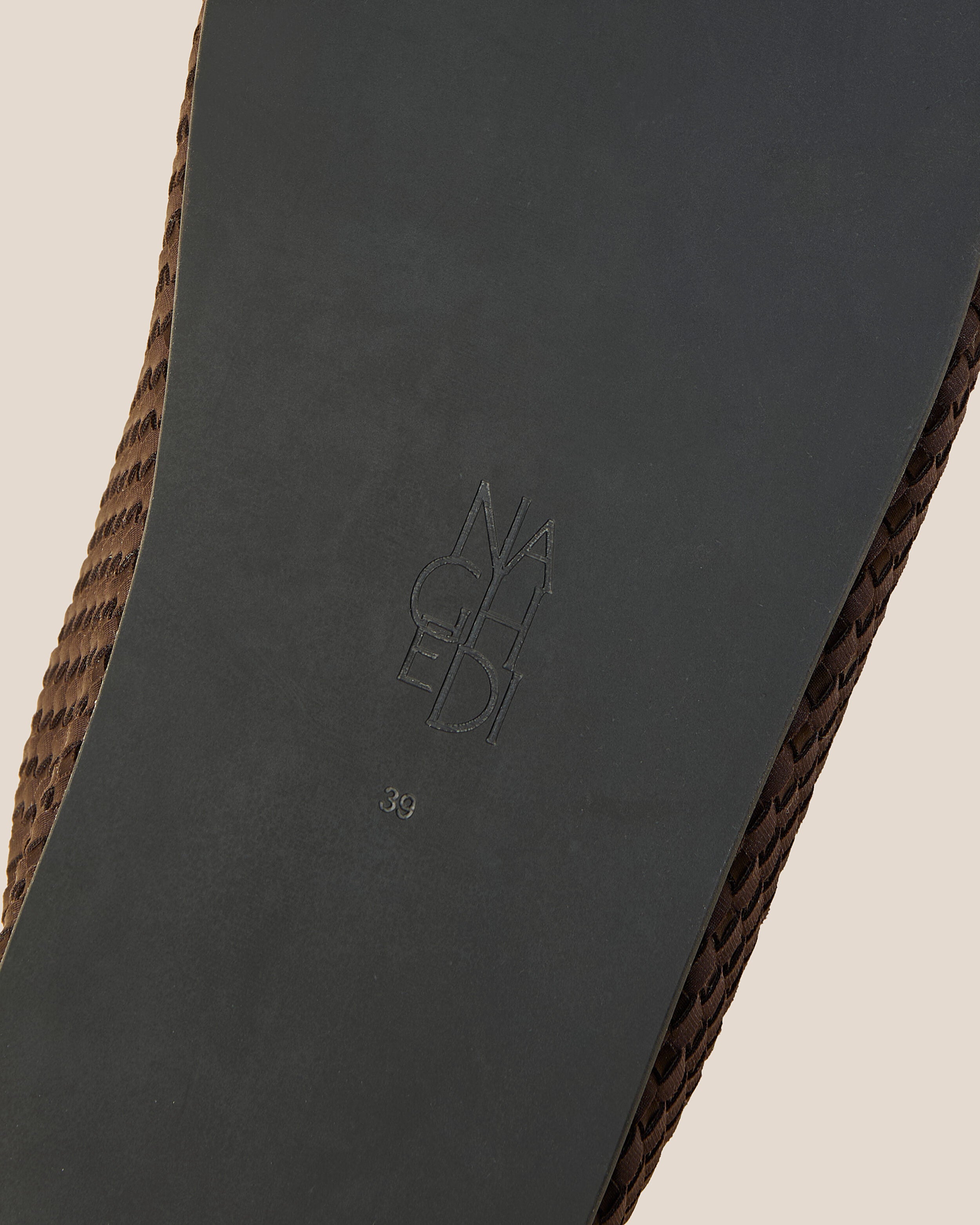 Shoe sole showing natural rubber sole, stamped NAGHEDI logo and size detail for The Hudson Clog in Chocolate.