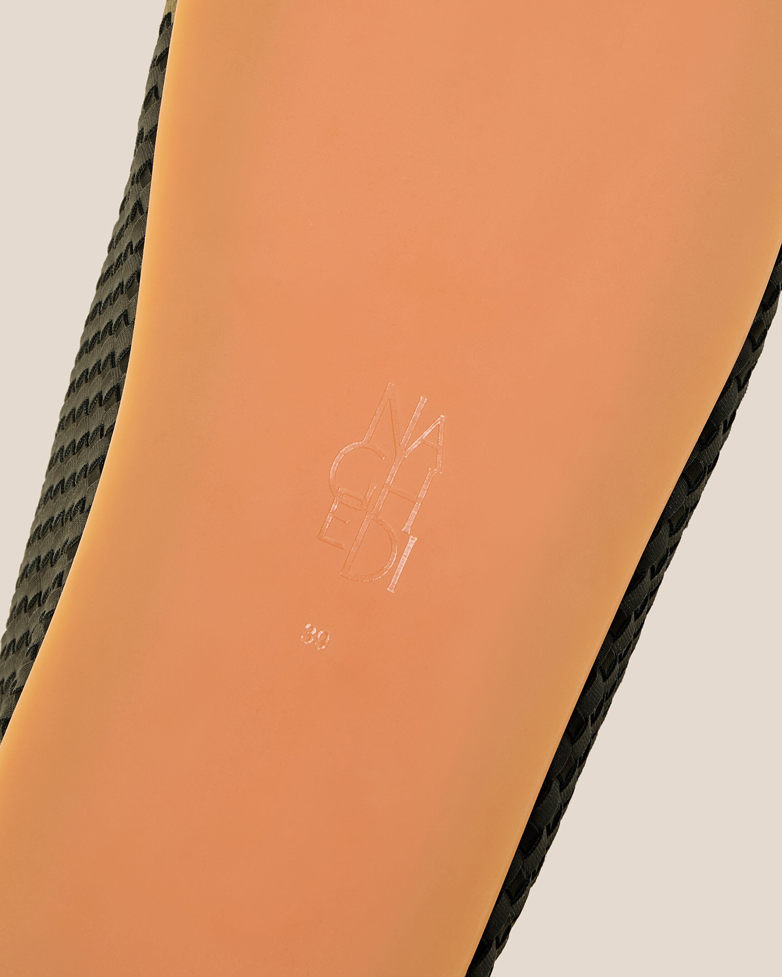 Shoe sole showing natural rubber sole, stamped NAGHEDI logo and size detail for The Hudson Clog in Olive.