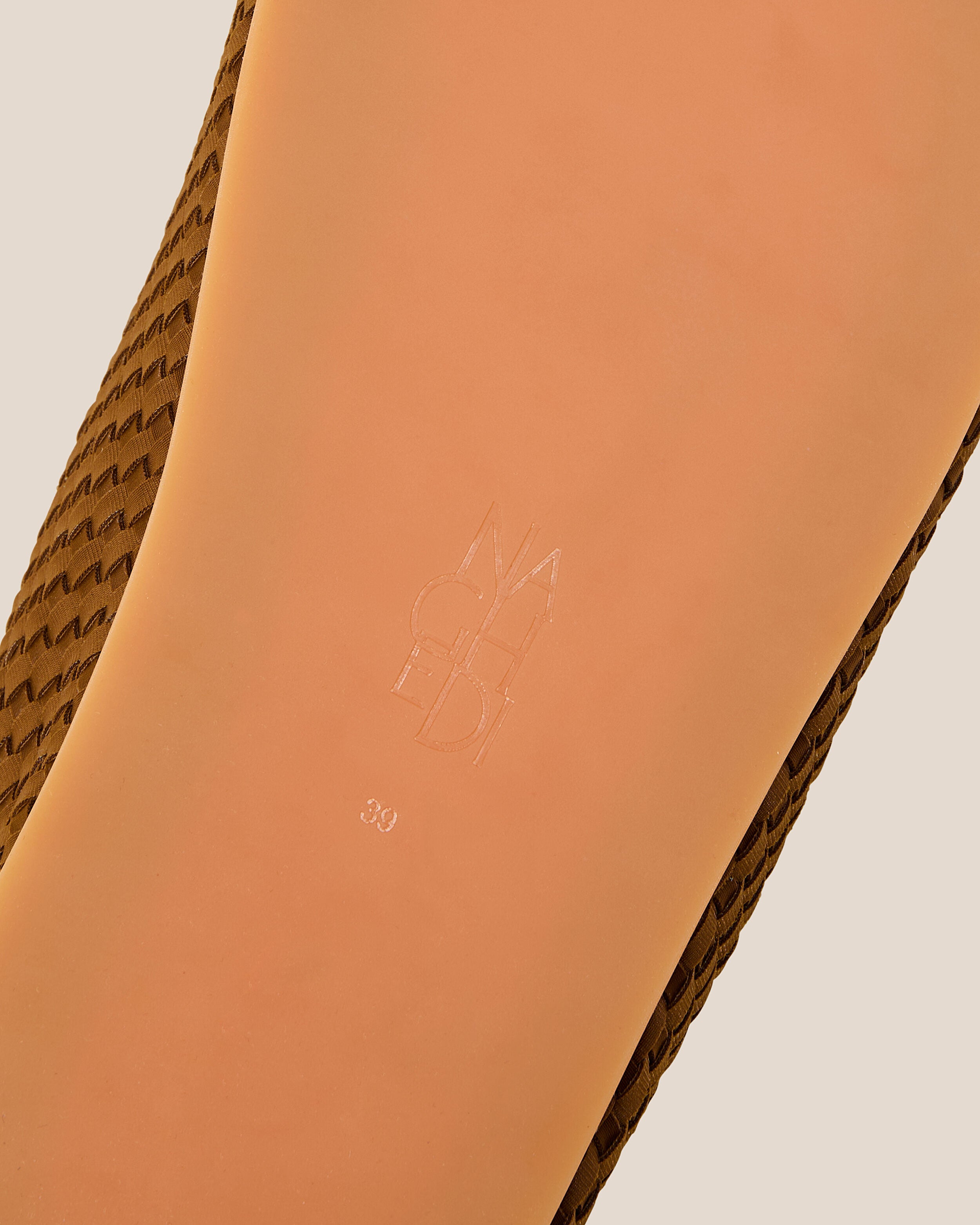 Shoe sole showing natural rubber sole, stamped NAGHEDI logo and size detail for The Hudson Clog in Teak.