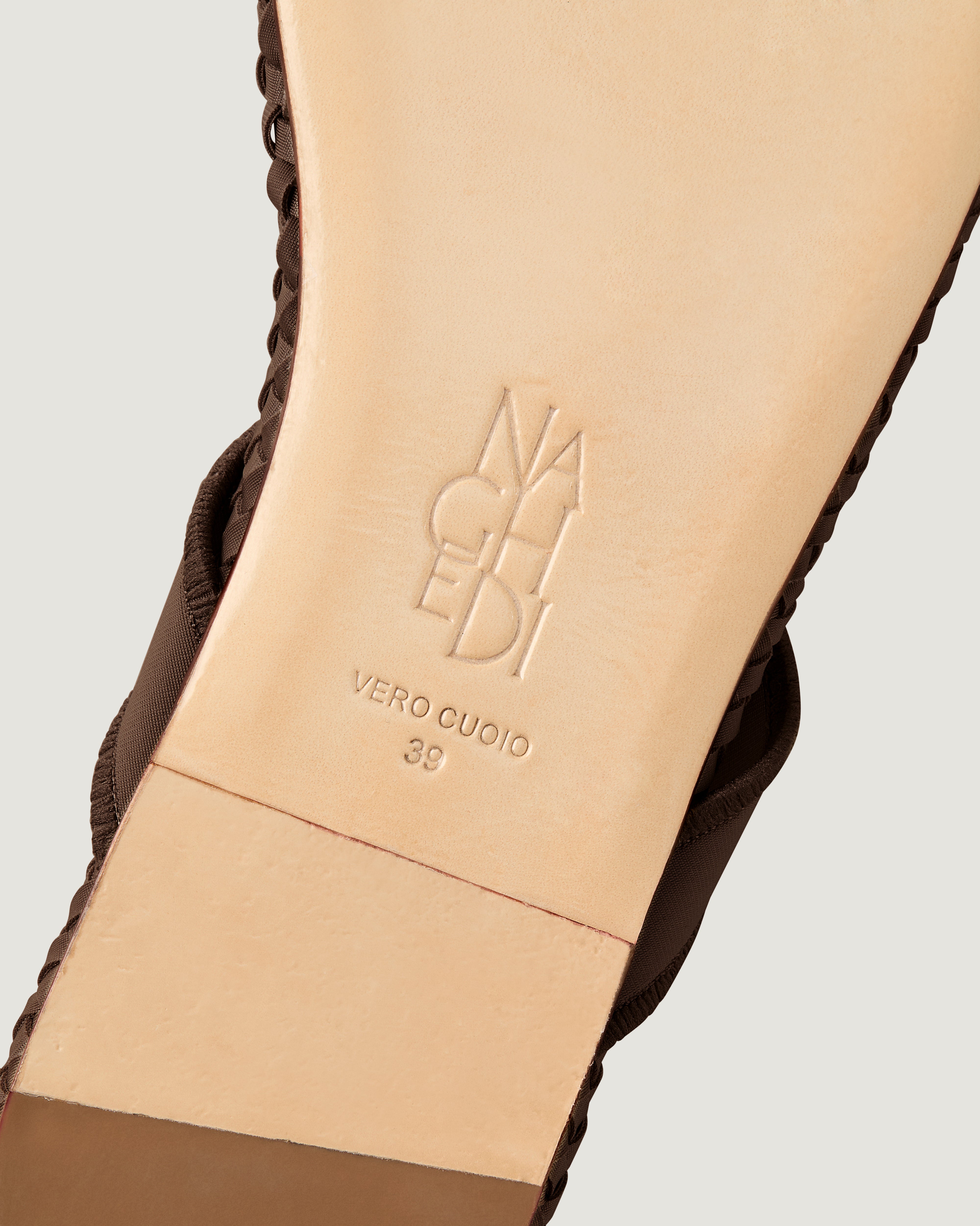 Shoe sole showing natural buffed leather sole, stamped NAGHEDI logo and size detail for The Hydra Flip Flop in Chocolate.