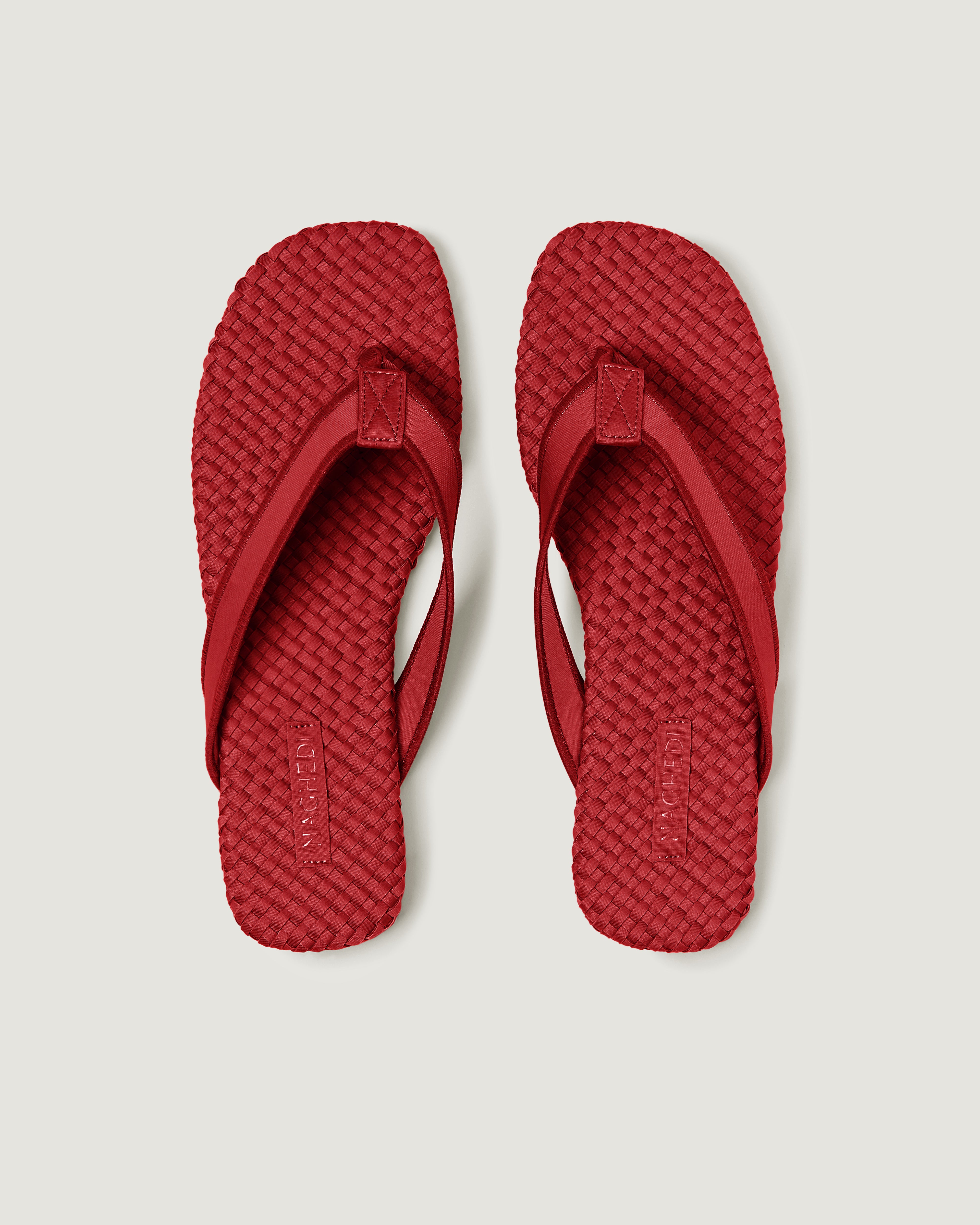 Top view of pair of The Hydra Flip Flop in Rosso showing the handwoven neoprene insole.