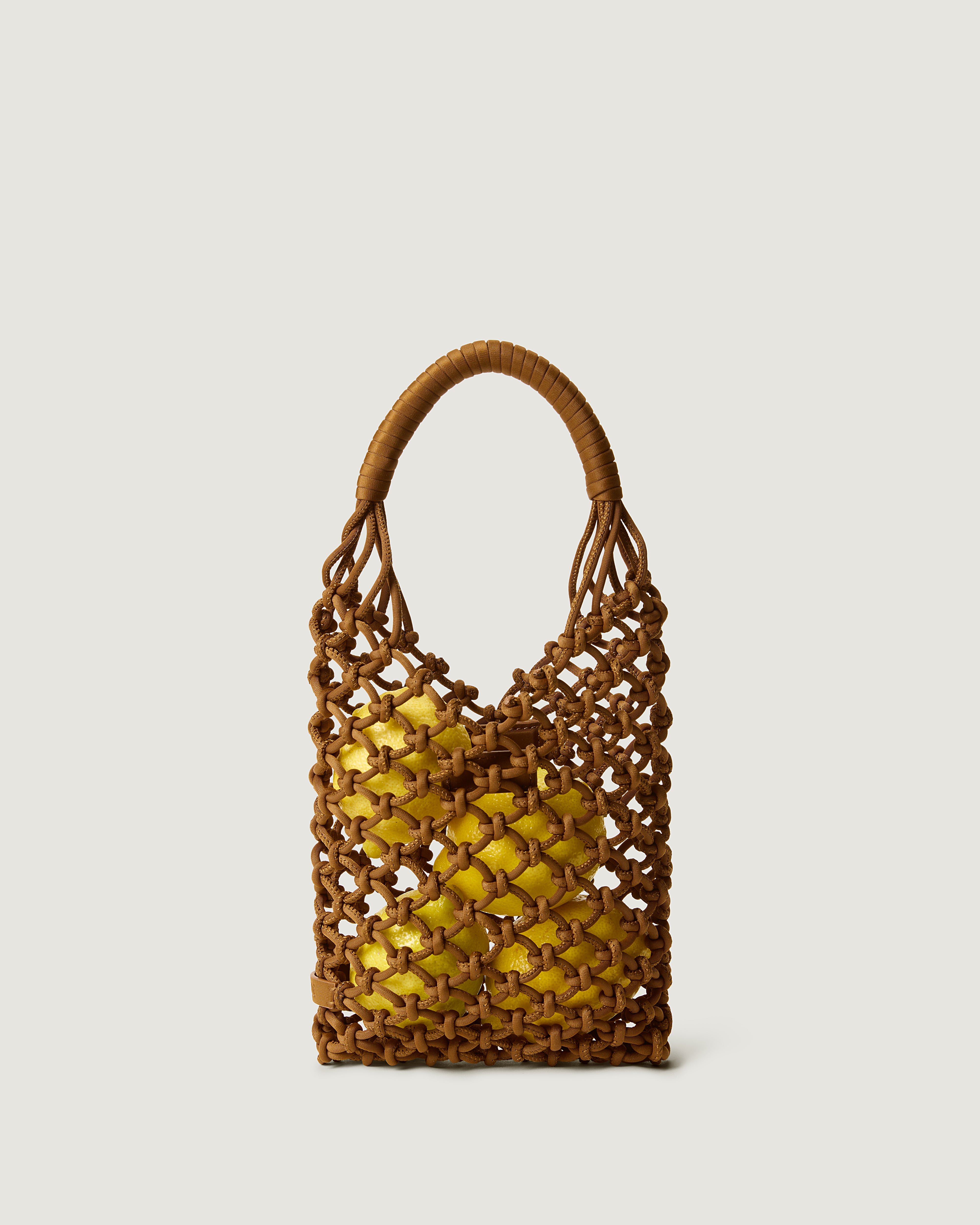 Image of small woven neoprene net bag in saddle brown with apples inside