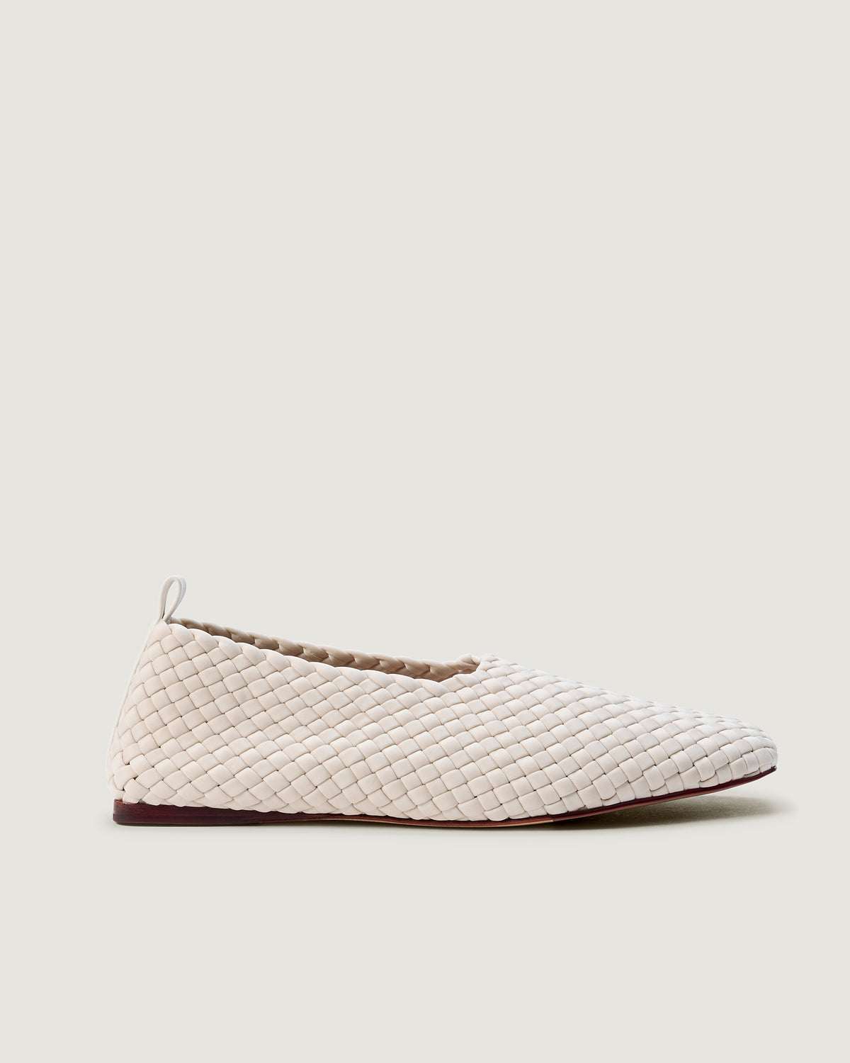 Side view of Jeju Glove Flat in Linen, an ivory tone, featuring a closed toe and round silhouette, featuring an adjustable strap with buckle closure.