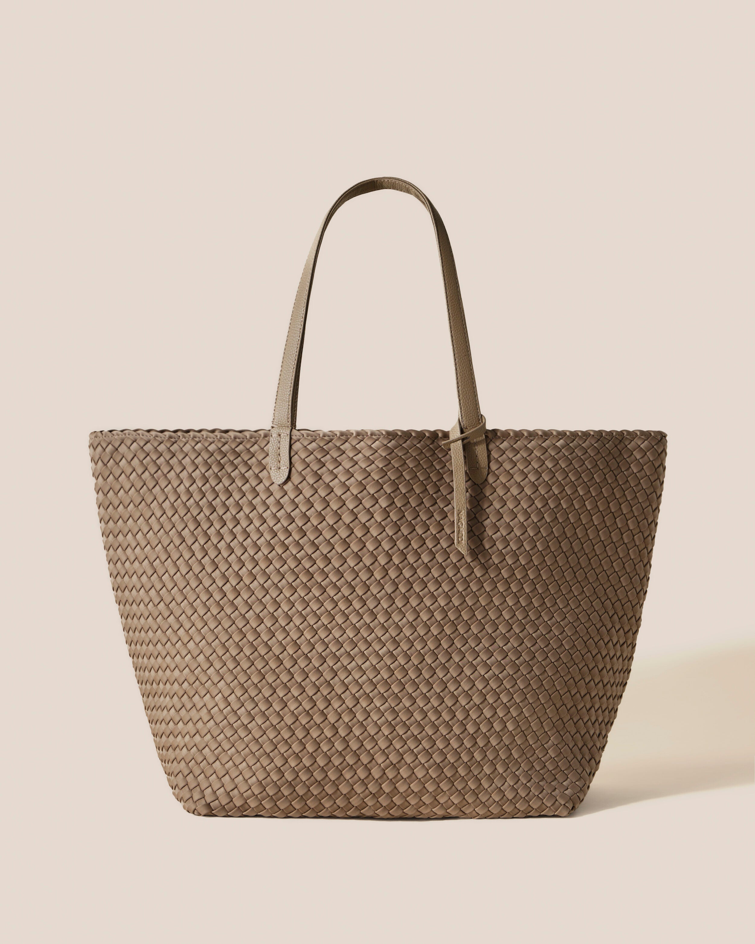 Jetsetter Tote in Cashmere, a taupe tone, in handwoven neoprene, featuring a top zip closure, and vegan leather handles.