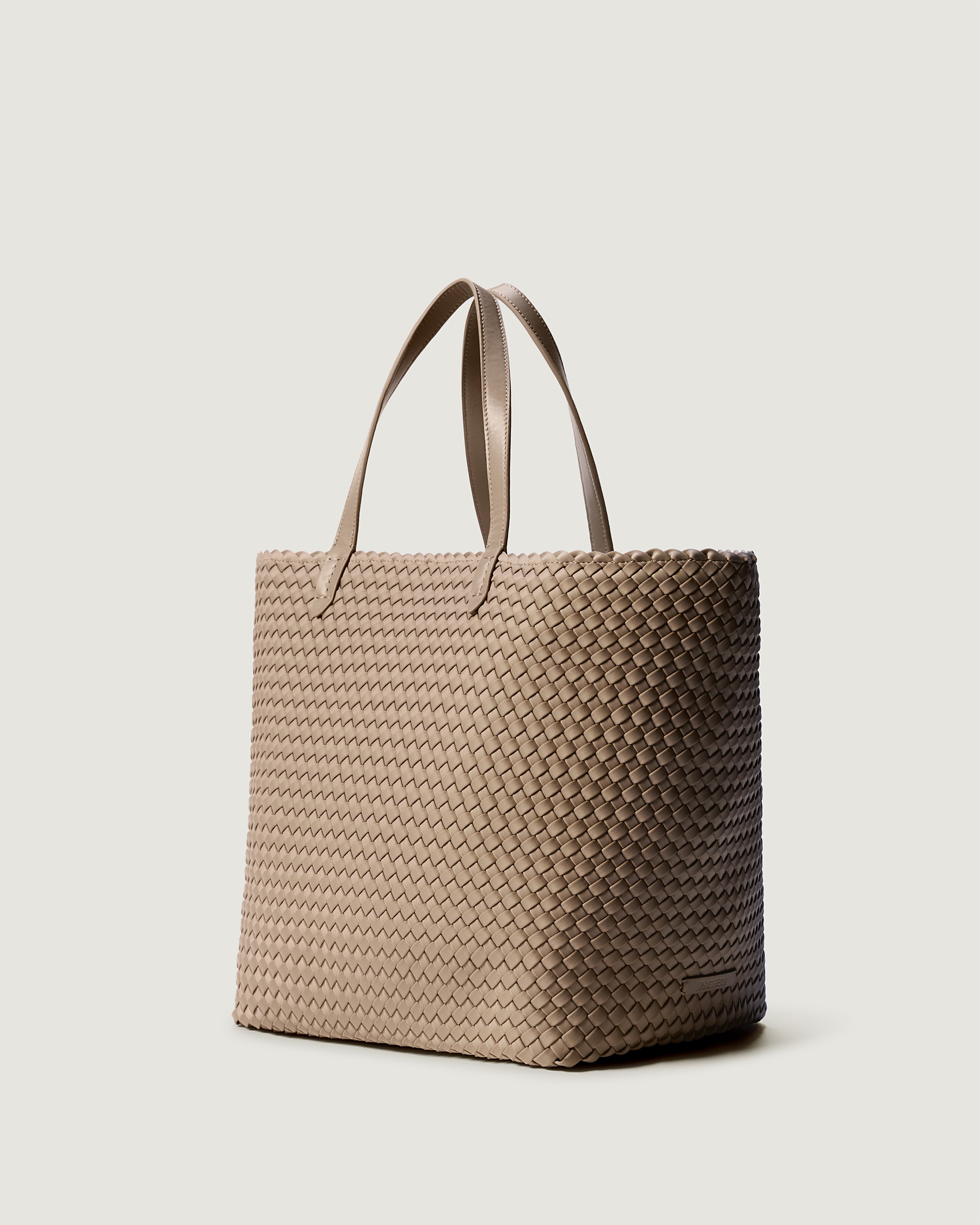 Jetsetter Tote in Cashmere shown from a side angle, highlighting its handwoven neoprene construction and top zip closure.