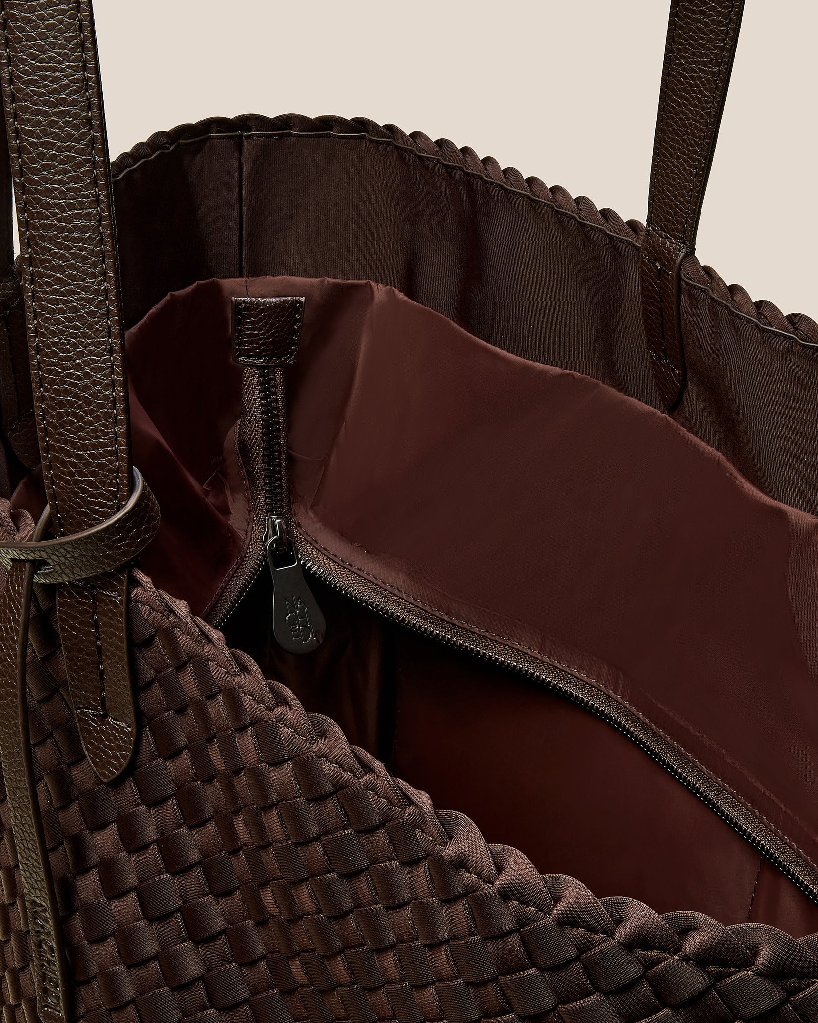Interior close-up of Jetsetter Large Tote Bag in Chocolate showing its top zip closure, interior pockets, and wipe-clean nylon interior.